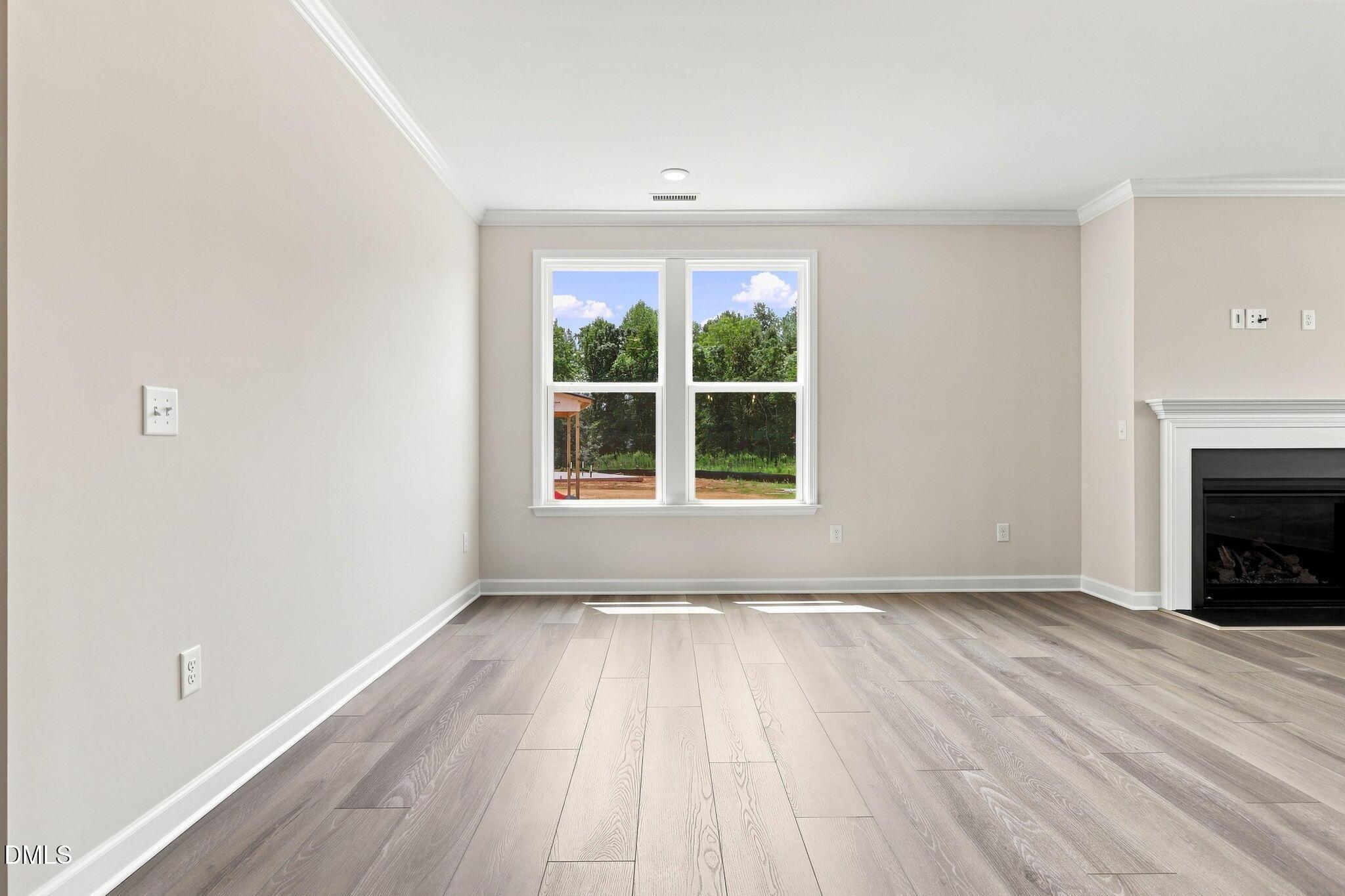 Bright living room with wood-look floors and fireplace in The Magnolia B floor plan at Retreat at North Main, Lillington.