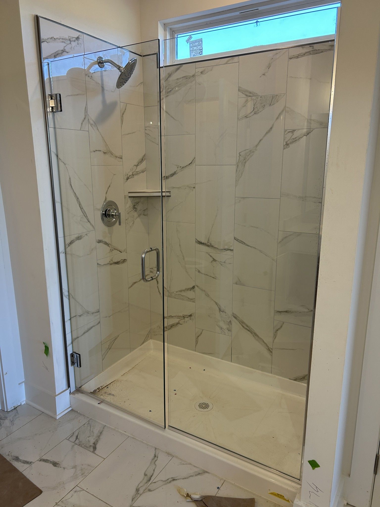 Frameless glass walk-in shower with marble tile walls and rainfall head in master bath of Davidson Homes The Ridgeport D, Mt. Juliet, TN