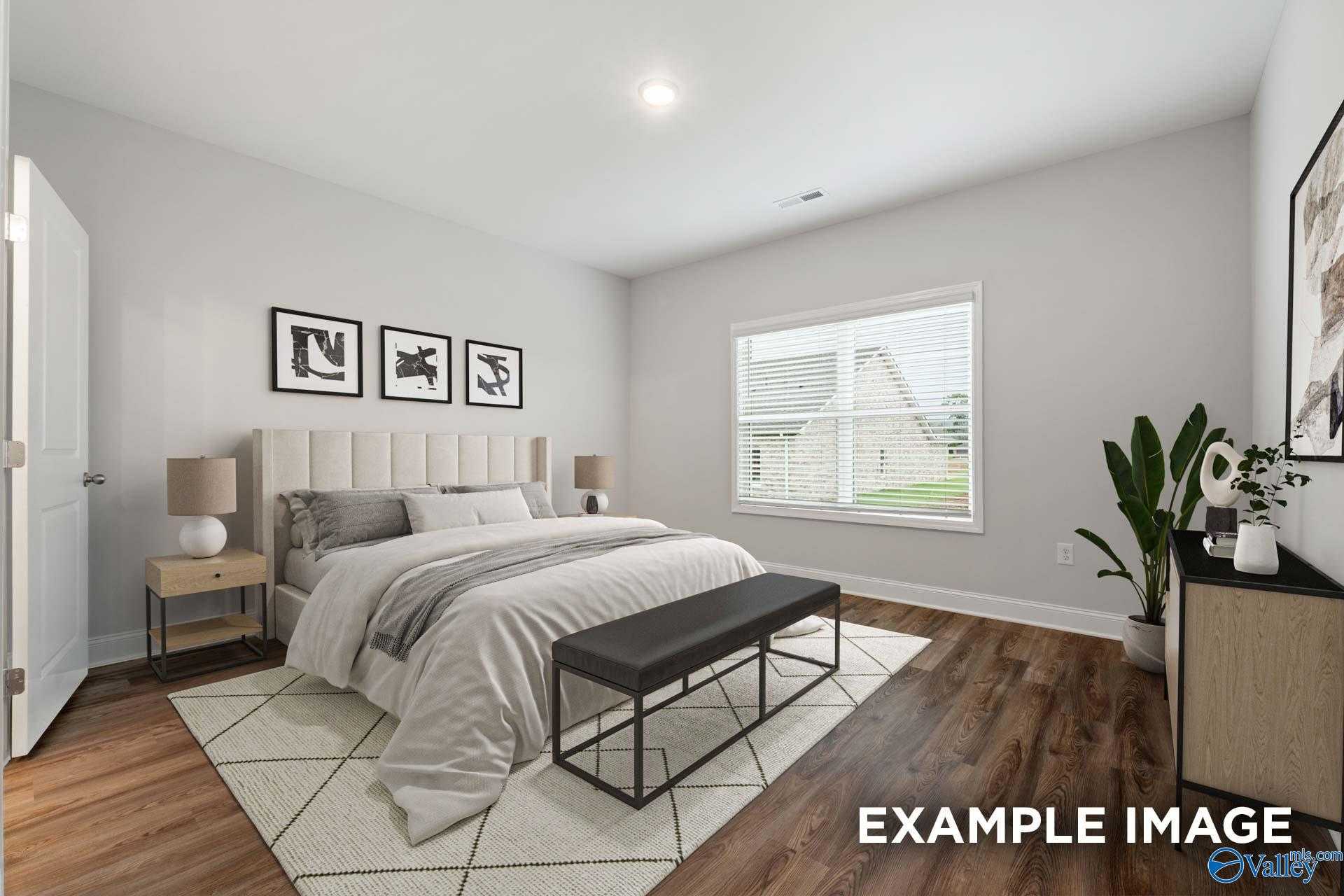 Cozy master bedroom with king bed, neutral gray walls, large window, and modern decor in Davidson Homes The Cumberland, Decatur, AL