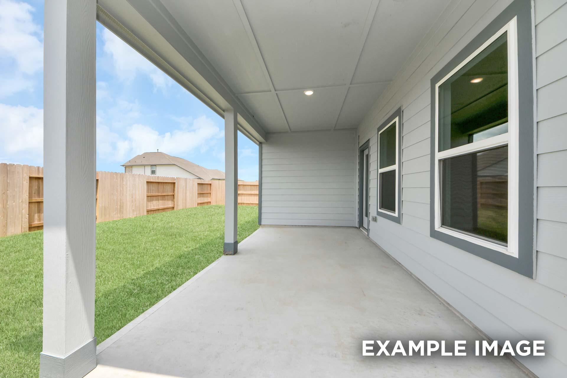 Covered back patio of The Sorrento in Crosby, Texas featuring a spacious concrete floor and fenced backyard view.