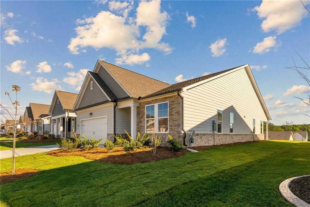 Modern single-story 3-bedroom home with 2-car garage, stone accents, and lush lawn in Kelly Preserve, Loganville, Georgia by Davidson Homes