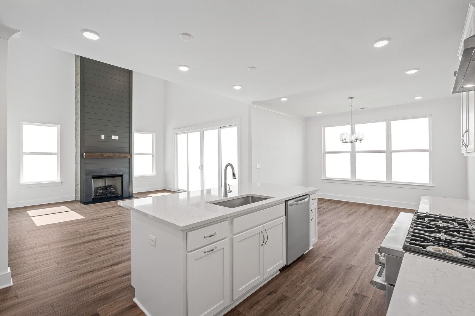 Open-concept kitchen and great room with quartz island, gas fireplace, hardwood floors in Davidson Homes The Hawkins, Murfreesboro, TN