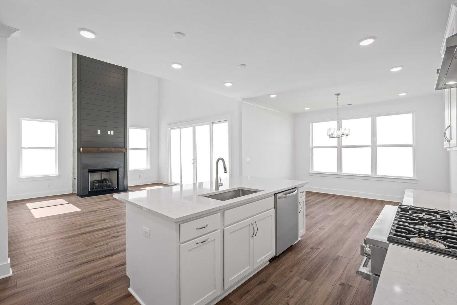 Open-concept kitchen and great room with quartz island, gas fireplace, hardwood floors in Davidson Homes The Hawkins, Murfreesboro, TN