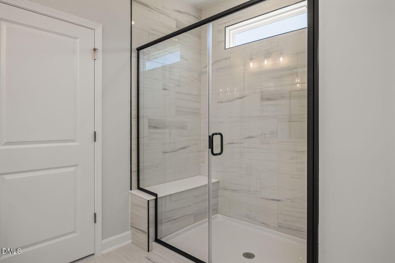 Modern walk-in shower with tile surround and black trim in The Birch II A floor plan at Montrose, Aberdeen, NC.