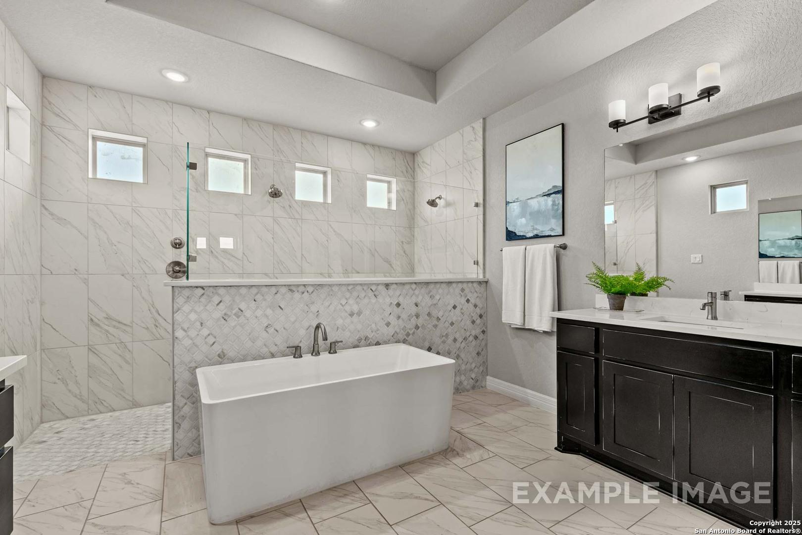 Elegant master bathroom with freestanding tub, frameless glass shower, double vanity in Davidson Homes Summerlin B, Castroville TX