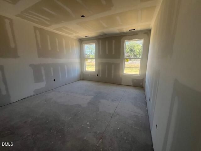 Unfinished bedroom with two windows and tray ceiling in Davidson Homes The Ash C floor plan, Lillington, North Carolina