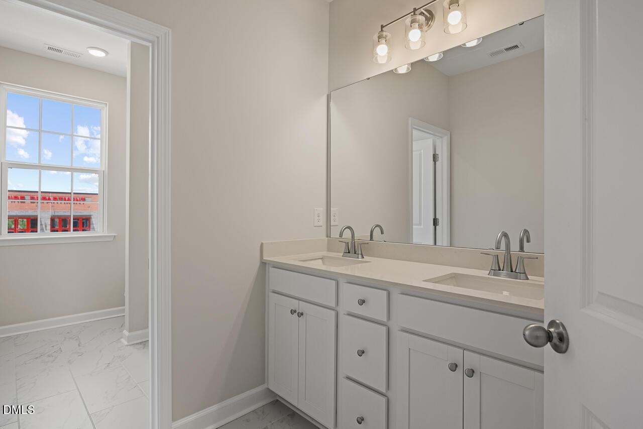 Modern bathroom with double vanity and large mirror in The Alexander C floor plan at Forestville Yard, Knightdale, NC.