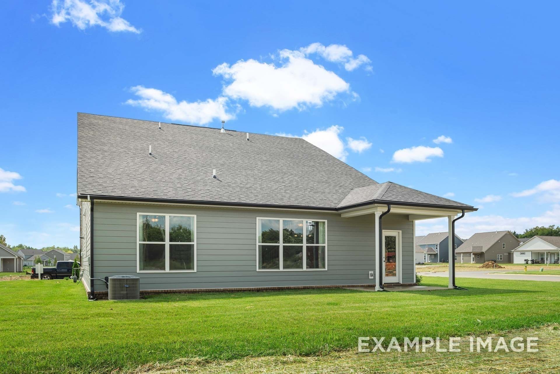 Modern two-story gray-sided home with covered porch, large windows, and lush green lawn in Woods Crossing, Gallatin, Tennessee - Davidson Homes The Ridgeport