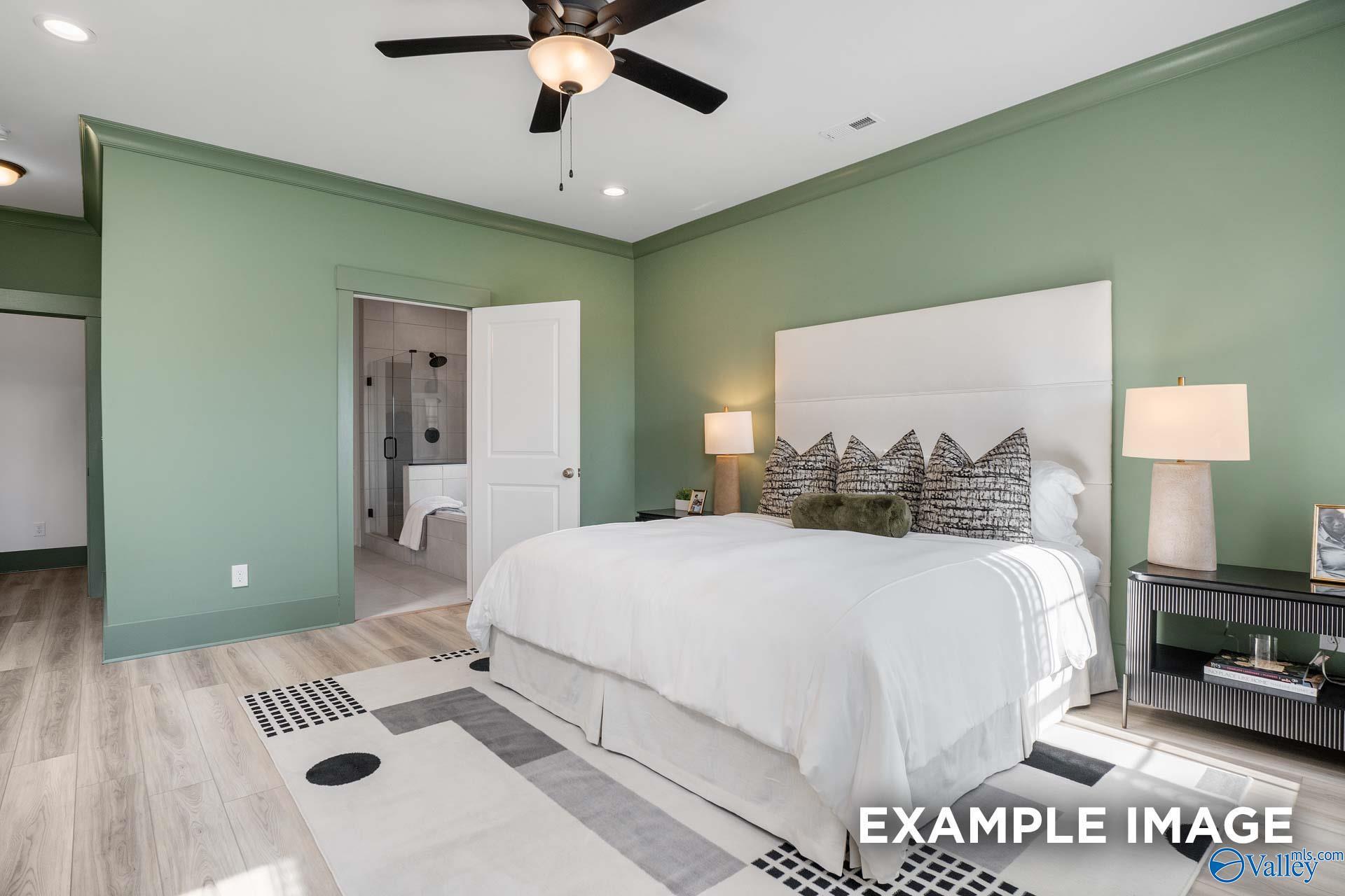 Elegant master bedroom with sage green walls, king bed, ceiling fan, en-suite bath in Davidson Homes The Rockford B, Madison AL