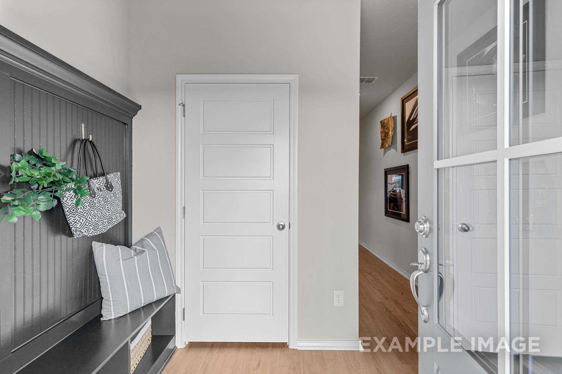 Functional entryway mudroom with gray built-in bench, coat hooks, handbag, and hallway in Davidson Homes The Sabine B, Agave, San Antonio