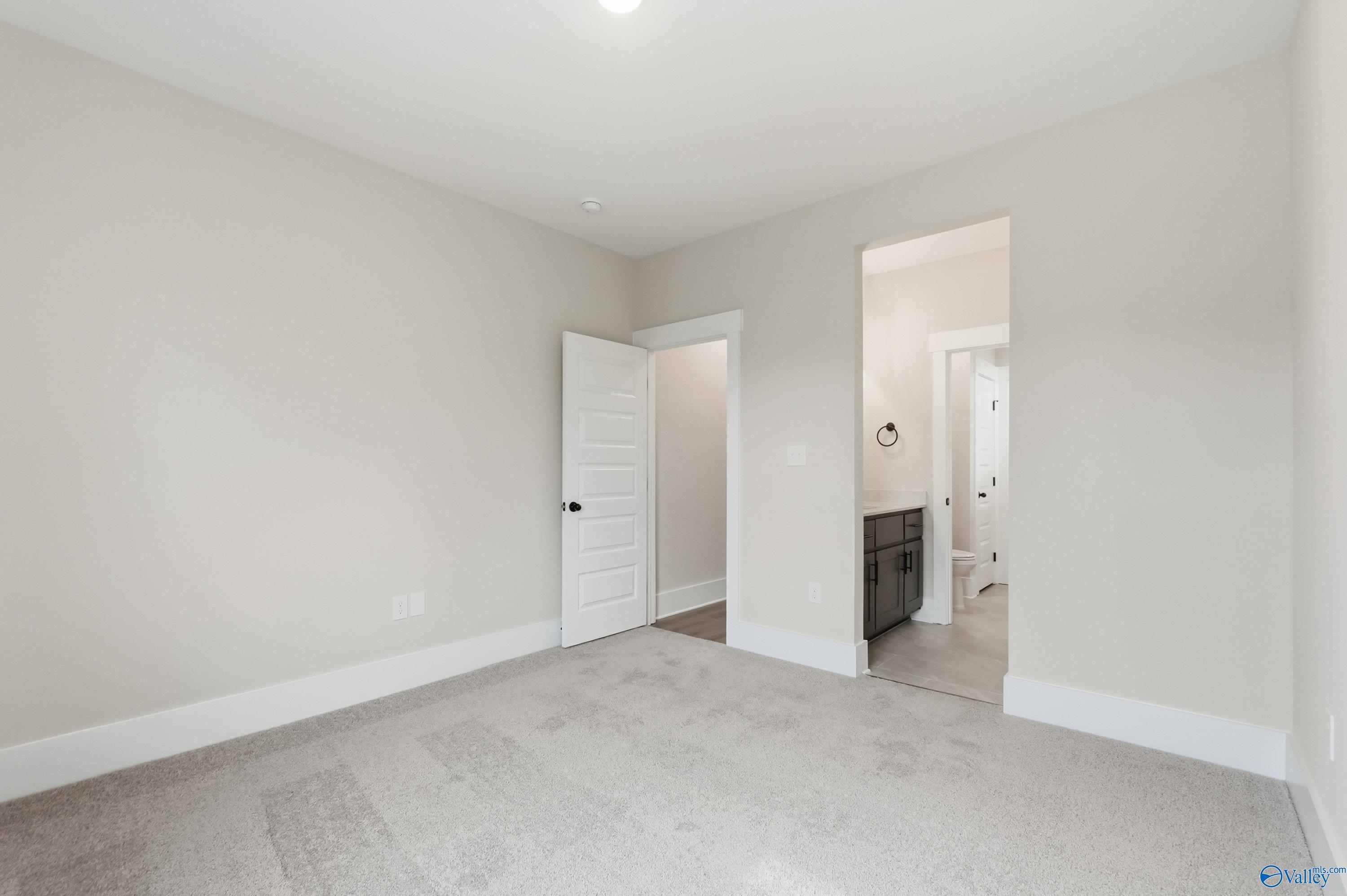 Bright secondary bedroom with en-suite bathroom vanity and open doorway in Davidson Homes The Finleigh, Meridianville, Alabama