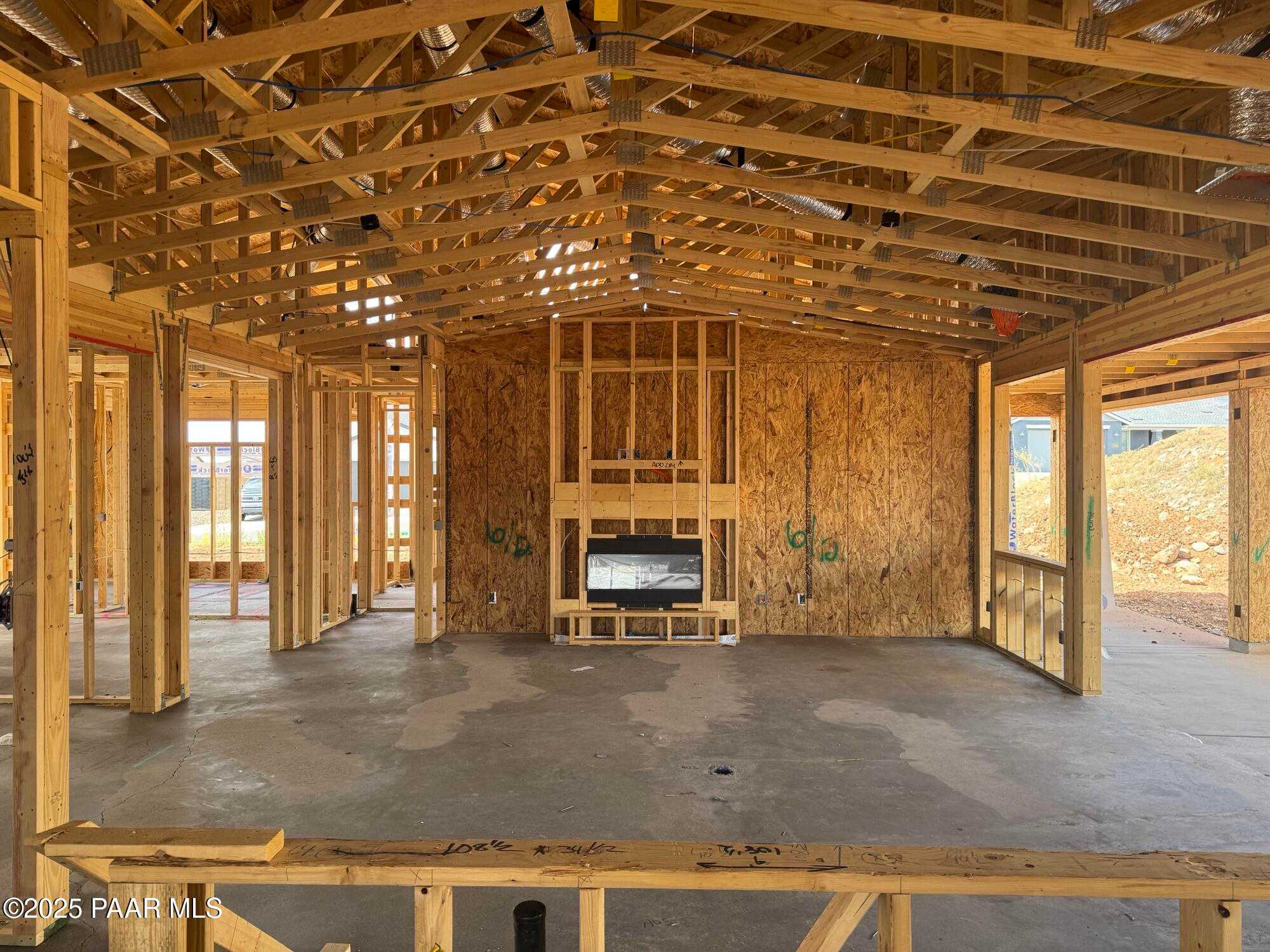 Exposed wooden framing in spacious great room with vaulted ceiling and fireplace, The Monarch B by Evermore Homes, Prescott Valley, AZ