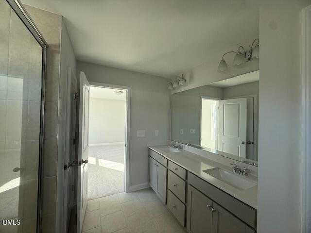 Modern master bathroom with frameless glass shower, double vanity, and large mirror in The Gavin B by Davidson Homes, Lillington, NC
