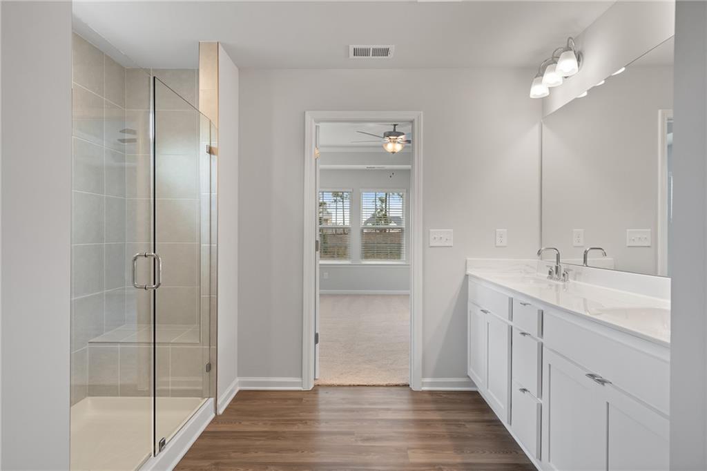 Modern master bath with frameless glass shower, double white vanity, and tile accents in Davidson Homes The Hickory A, Winder, GA