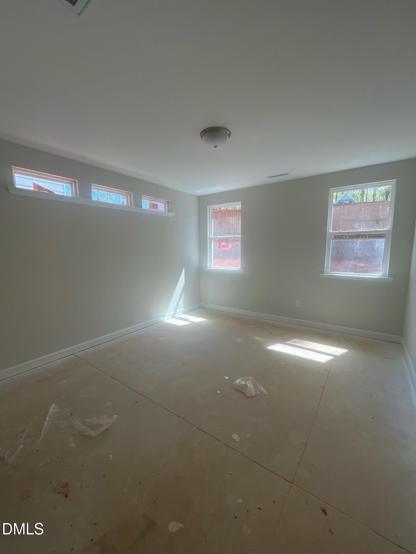 Bright empty primary bedroom with clerestory windows, natural light, and subfloor in Davidson Homes Ashport G, Wake Forest NC