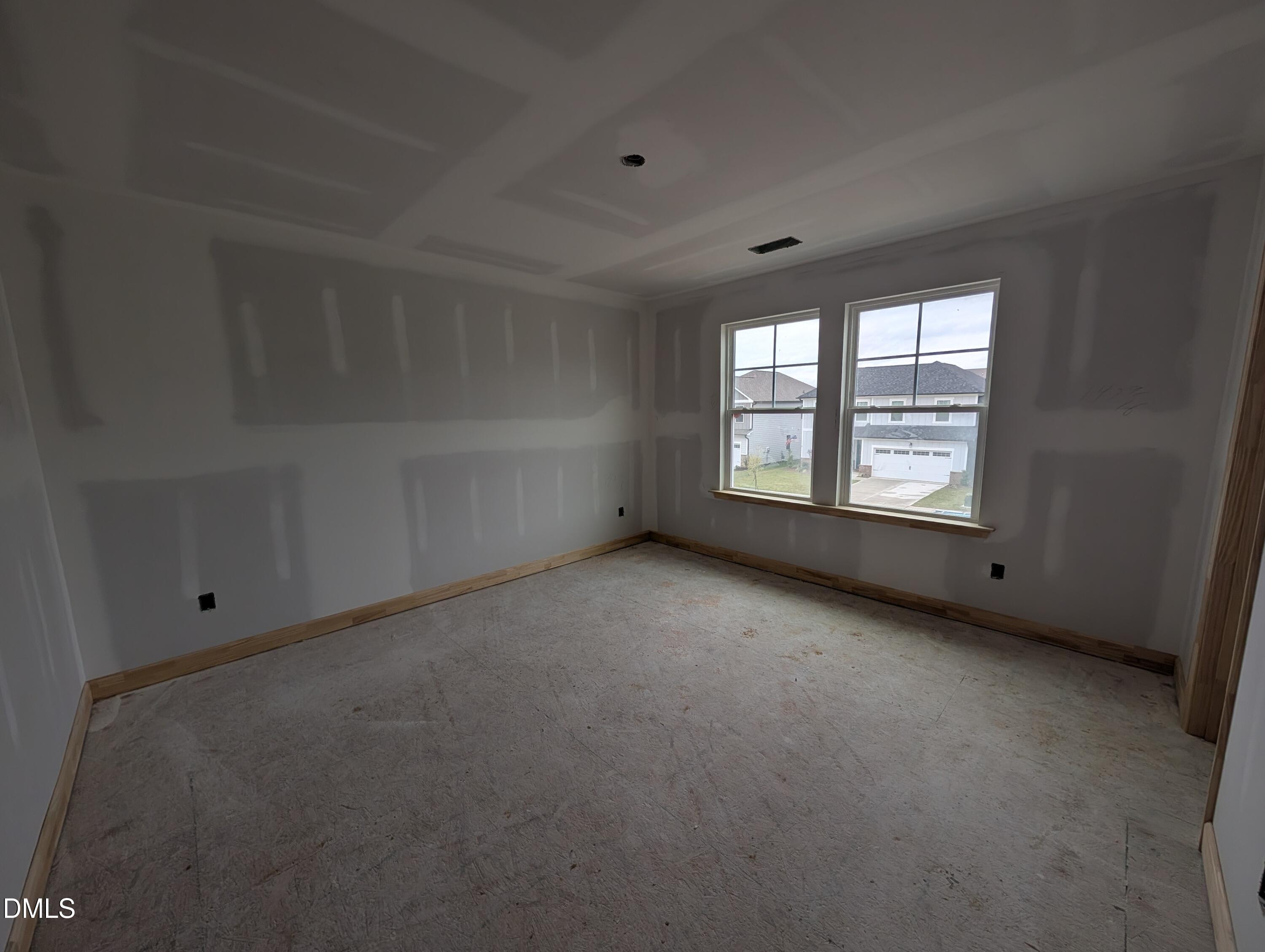 Unfinished bedroom with double windows and wood trim in Davidson Homes The Beech floor plan, Wendell Ridge, North Carolina