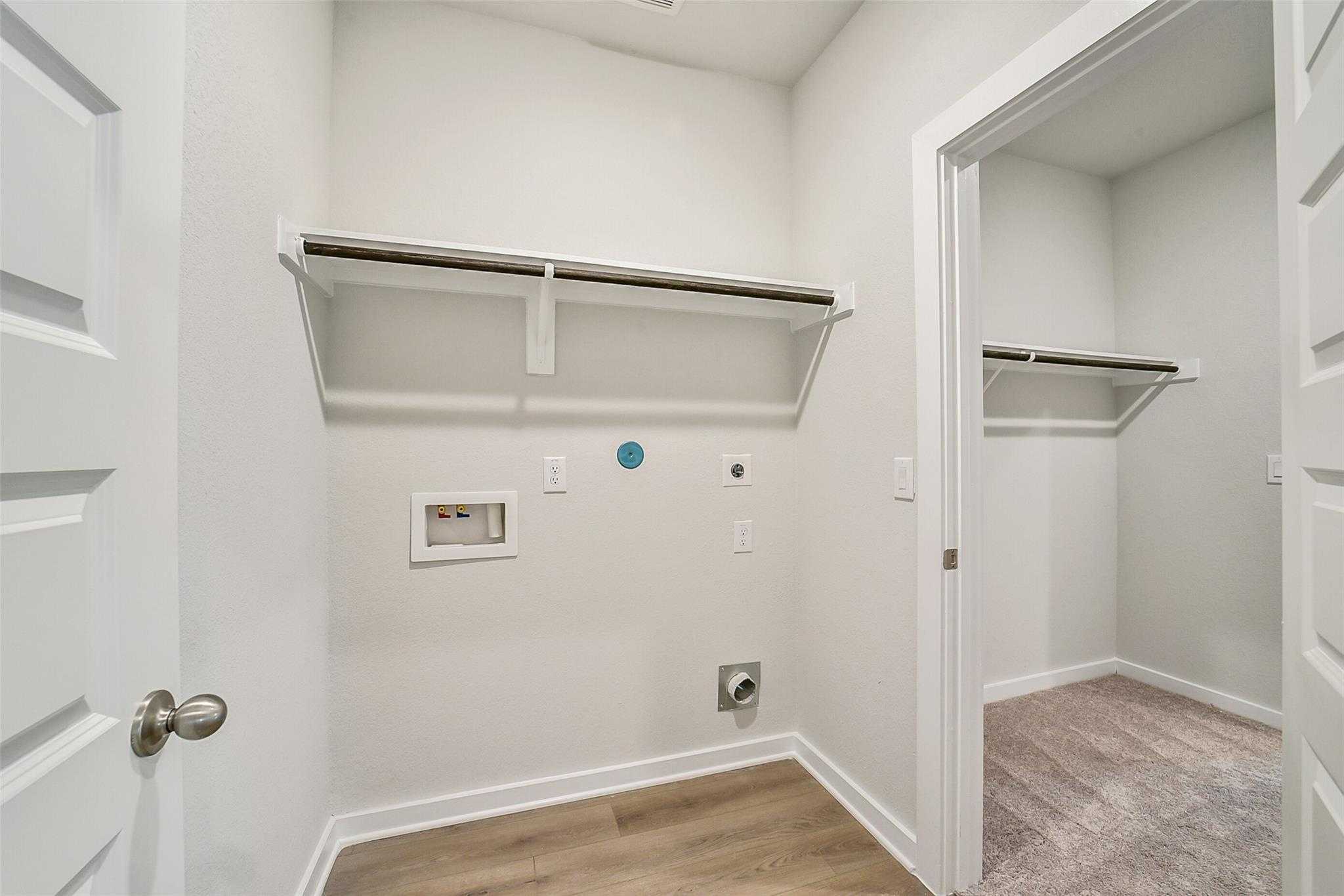 Spacious laundry room with built-in shelves, washer-dryer hookups in Davidson Homes The Blanco E, Magnolia Texas