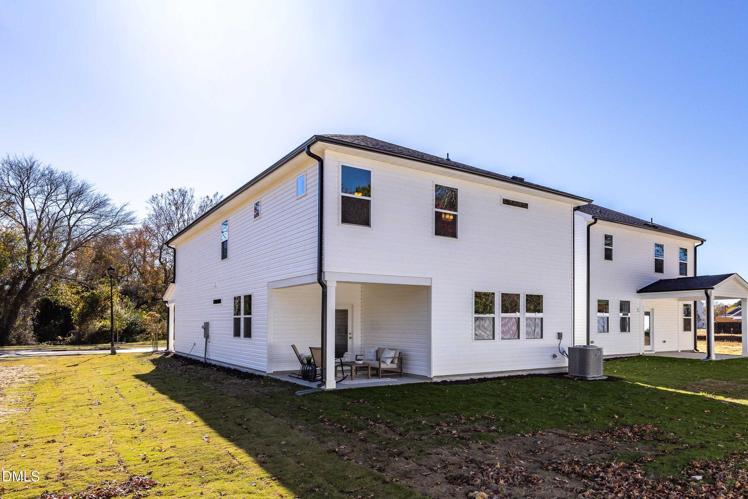 Two-story white Preston C home exterior by Davidson Homes in Gregory Village, Lillington, NC, with covered porch, garage, and green lawn
