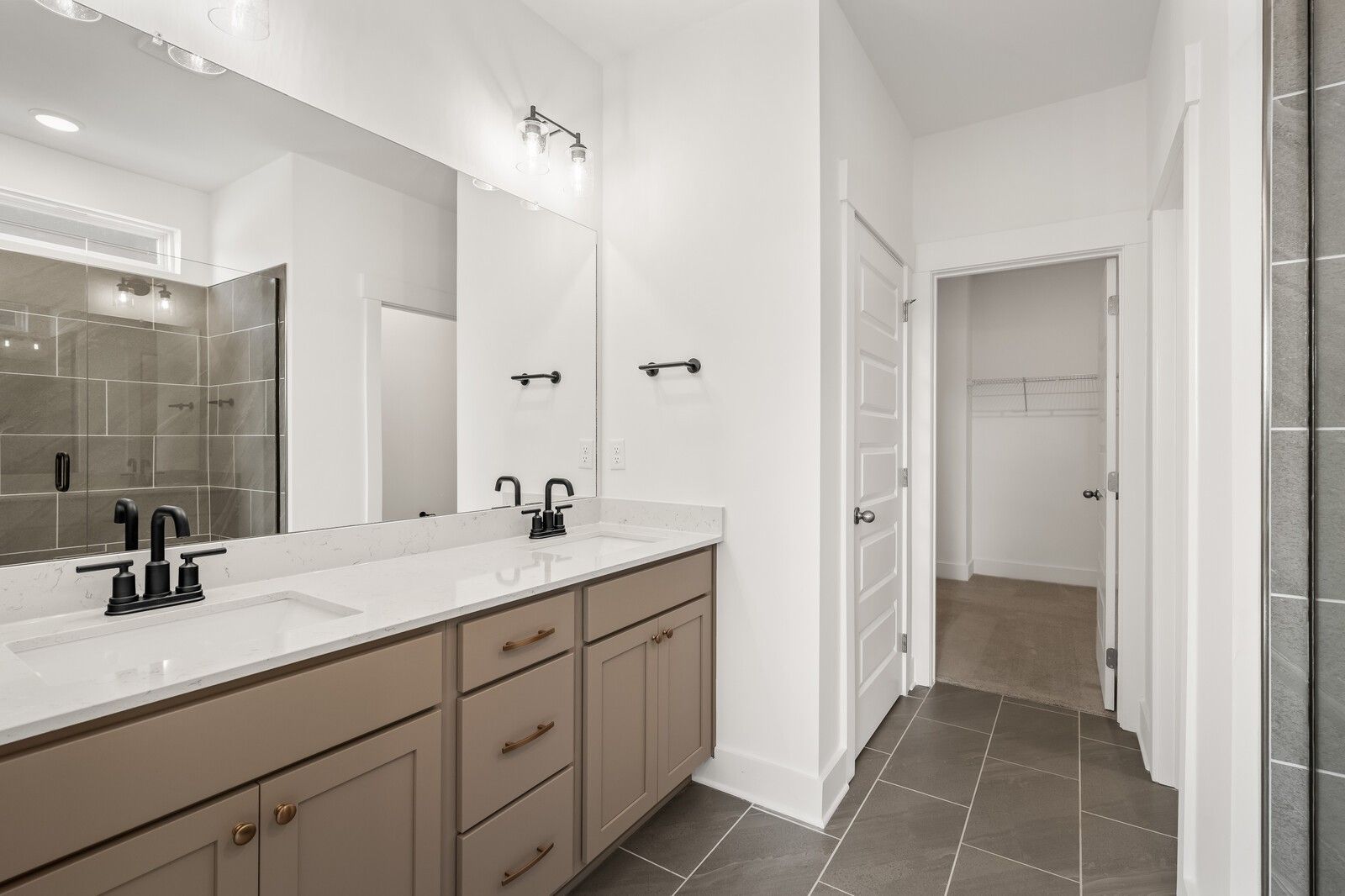 Modern master bathroom with double beige vanity, quartz counters, dual sinks, and glass walk-in shower in Davidson Homes The Ash A, Gallatin, TN