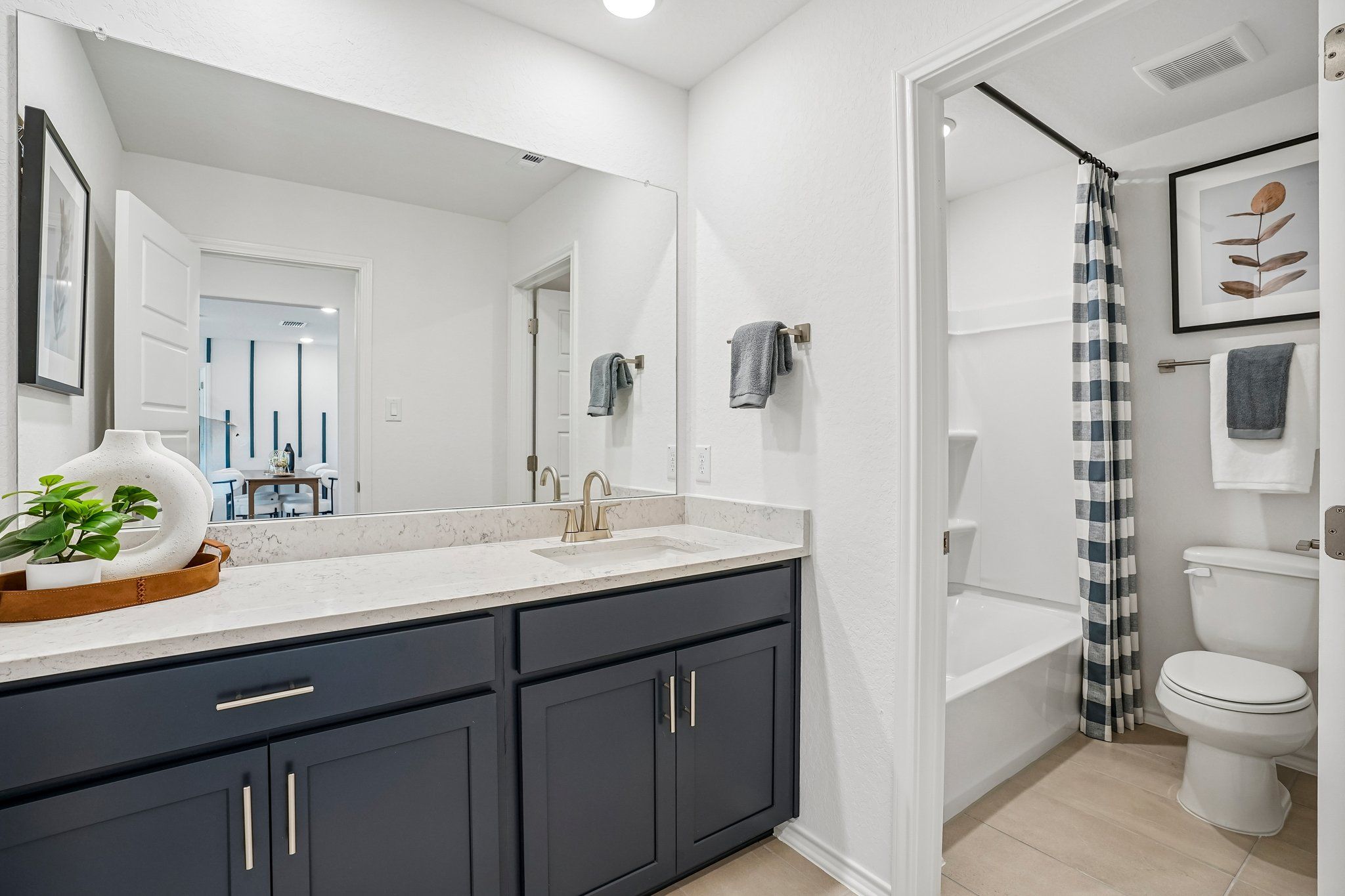 Modern bathroom with dark navy vanity and white quartz countertop at Morgan Meadows in San Antonio by Davidson Homes.