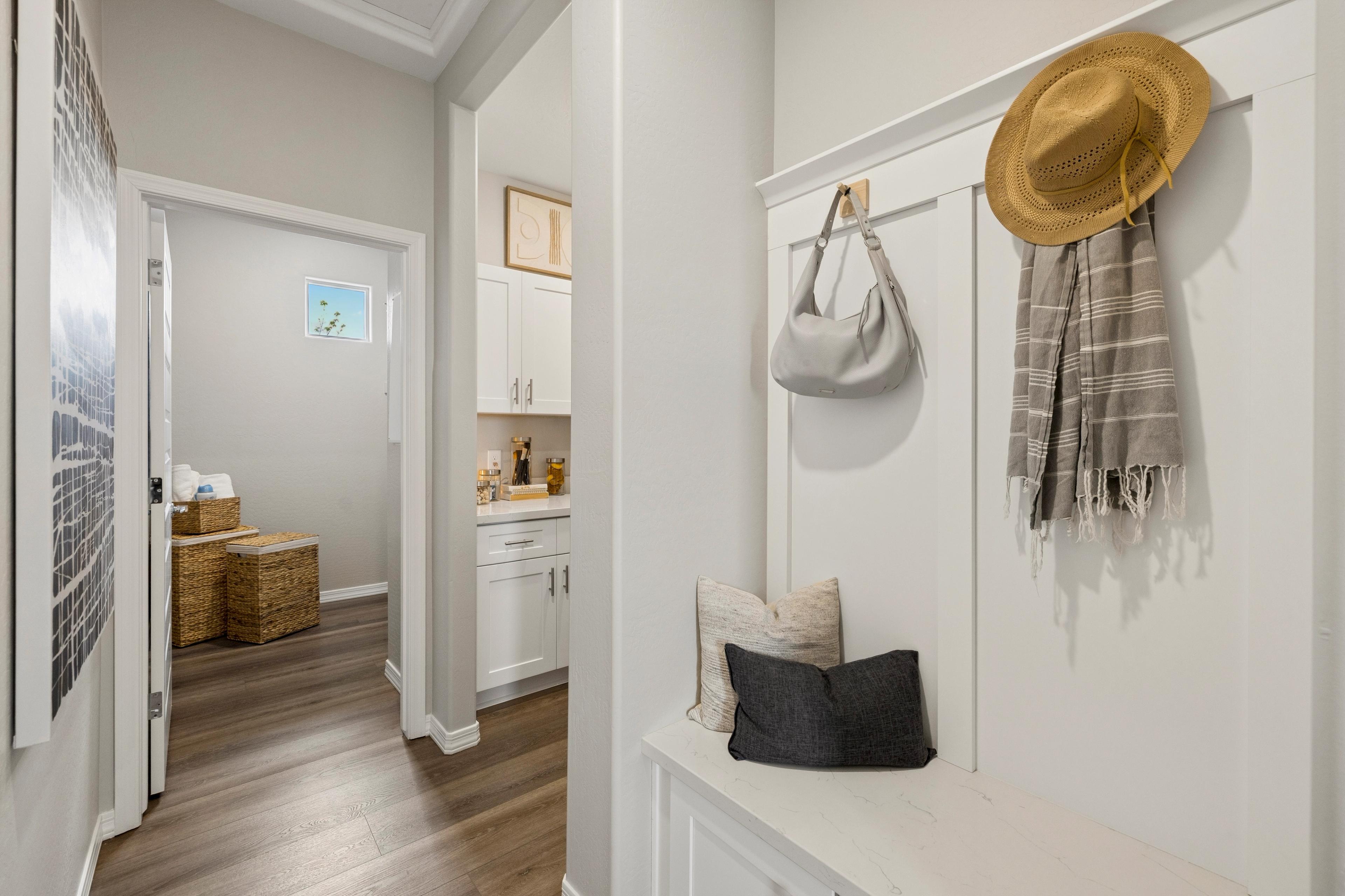 Cozy mudroom bench with pillows, straw hat, tote bag, scarf in South Ranch Prescott Arizona by Davidson Homes
