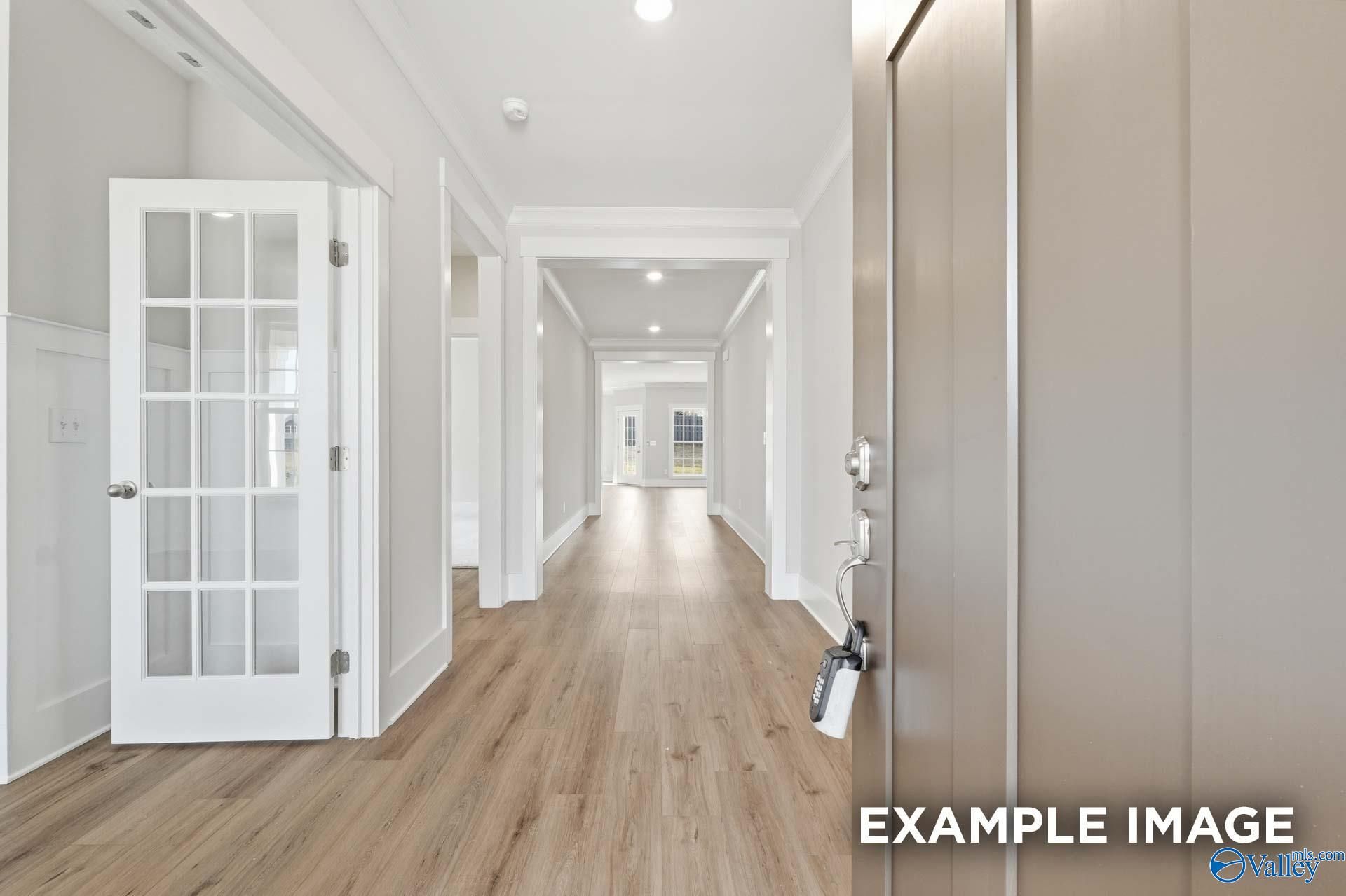 Bright foyer and hallway with luxury vinyl plank flooring in The Harrison floor plan by Davidson Homes in Briercreek.