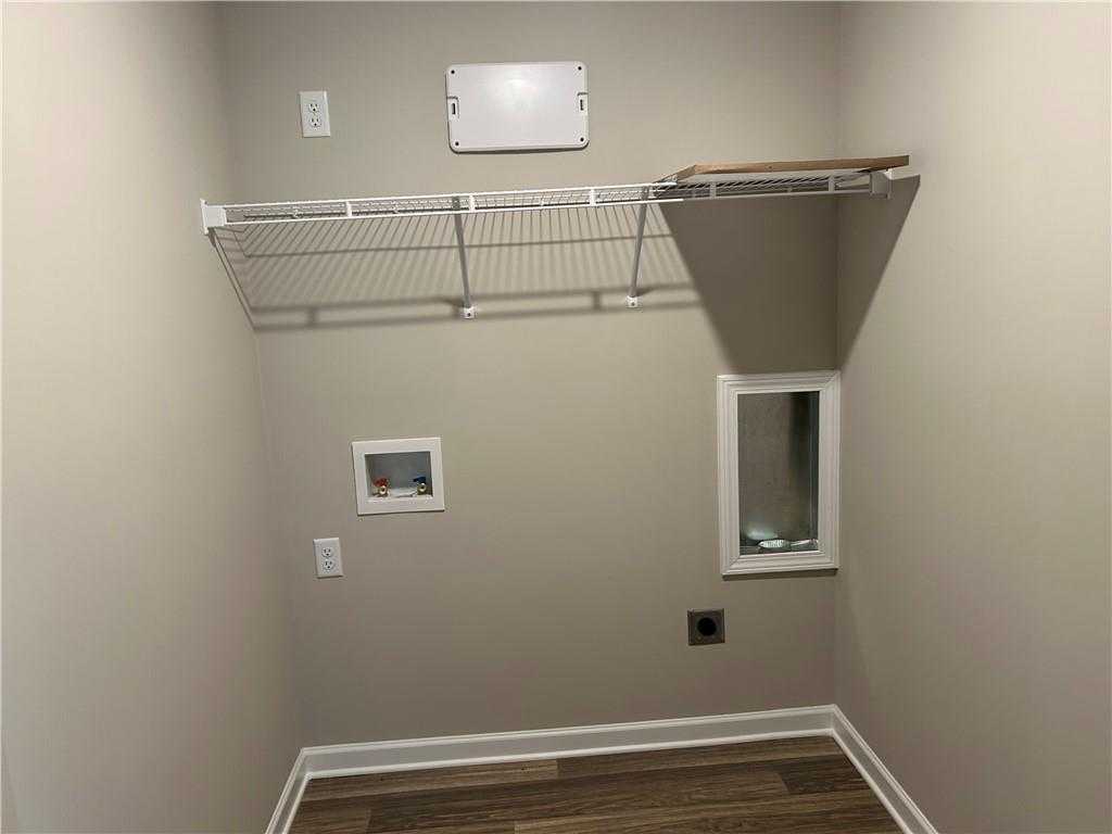 Organized laundry room with wire shelving, dryer vent, and outlets in The Washington floor plan by Davidson Homes, Phenix City, Alabama