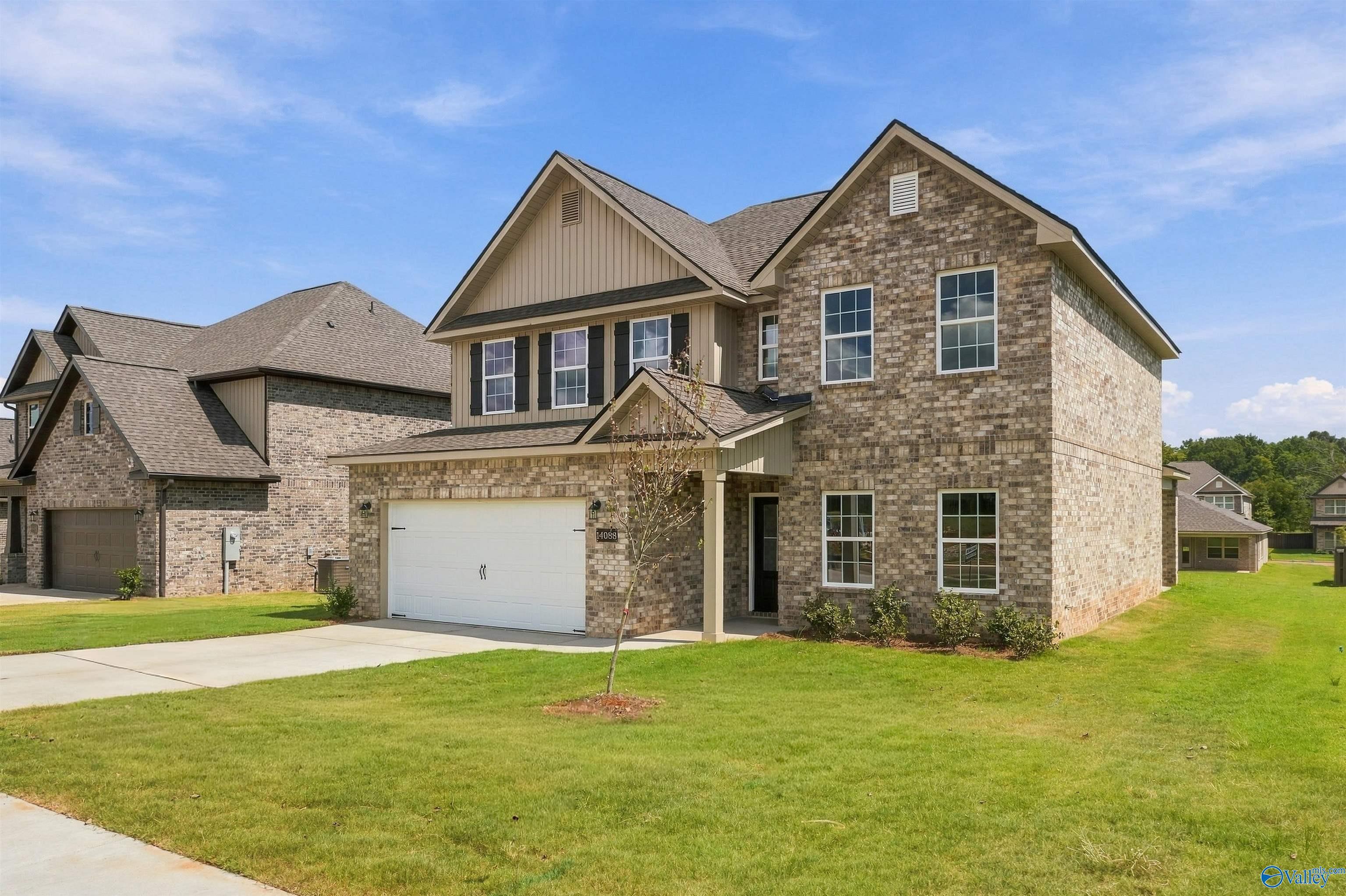 Two-story brick Davidson Homes The Shelby A with 2-car garage and manicured lawn in The Meadows, Athens, Alabama.