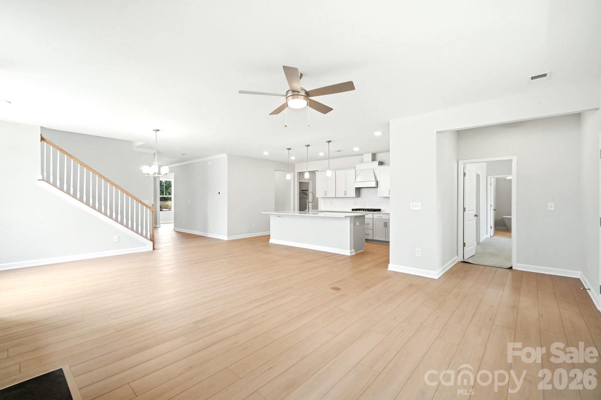 Open-concept floor plan with hardwood floors and modern kitchen in The Magnolia B by Davidson Homes in Windgate, Mooresville.