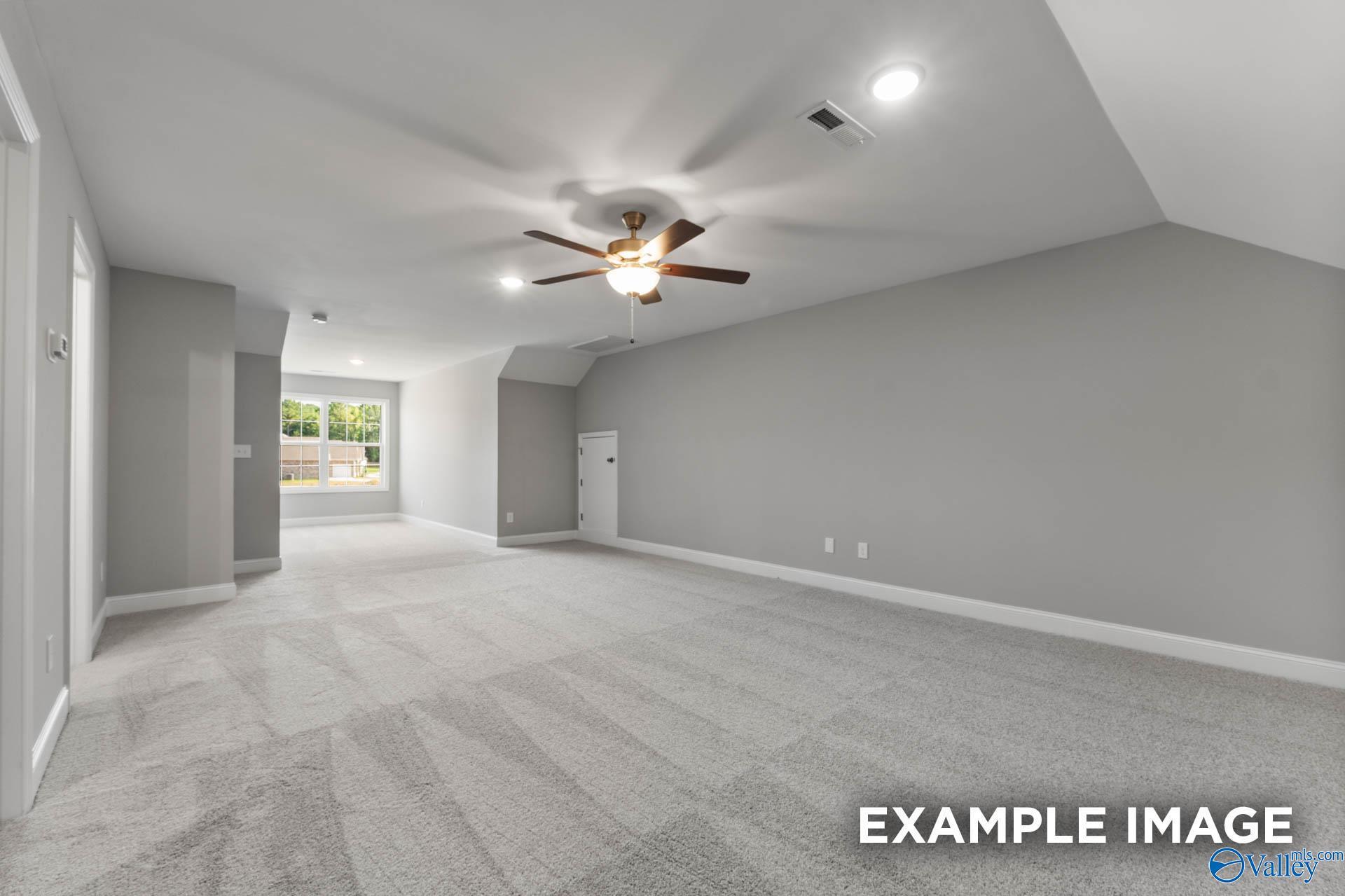 Spacious bonus room with sloped ceilings, ceiling fan, recessed lights, and large windows in Davidson Homes The Rockford, Madison, Alabama