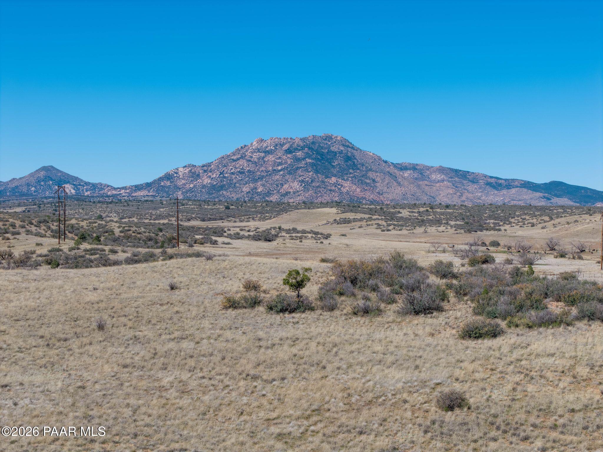 Scenic desert landscape with rugged mountains and sparse shrubs under clear blue sky in Westwood, Prescott, Arizona