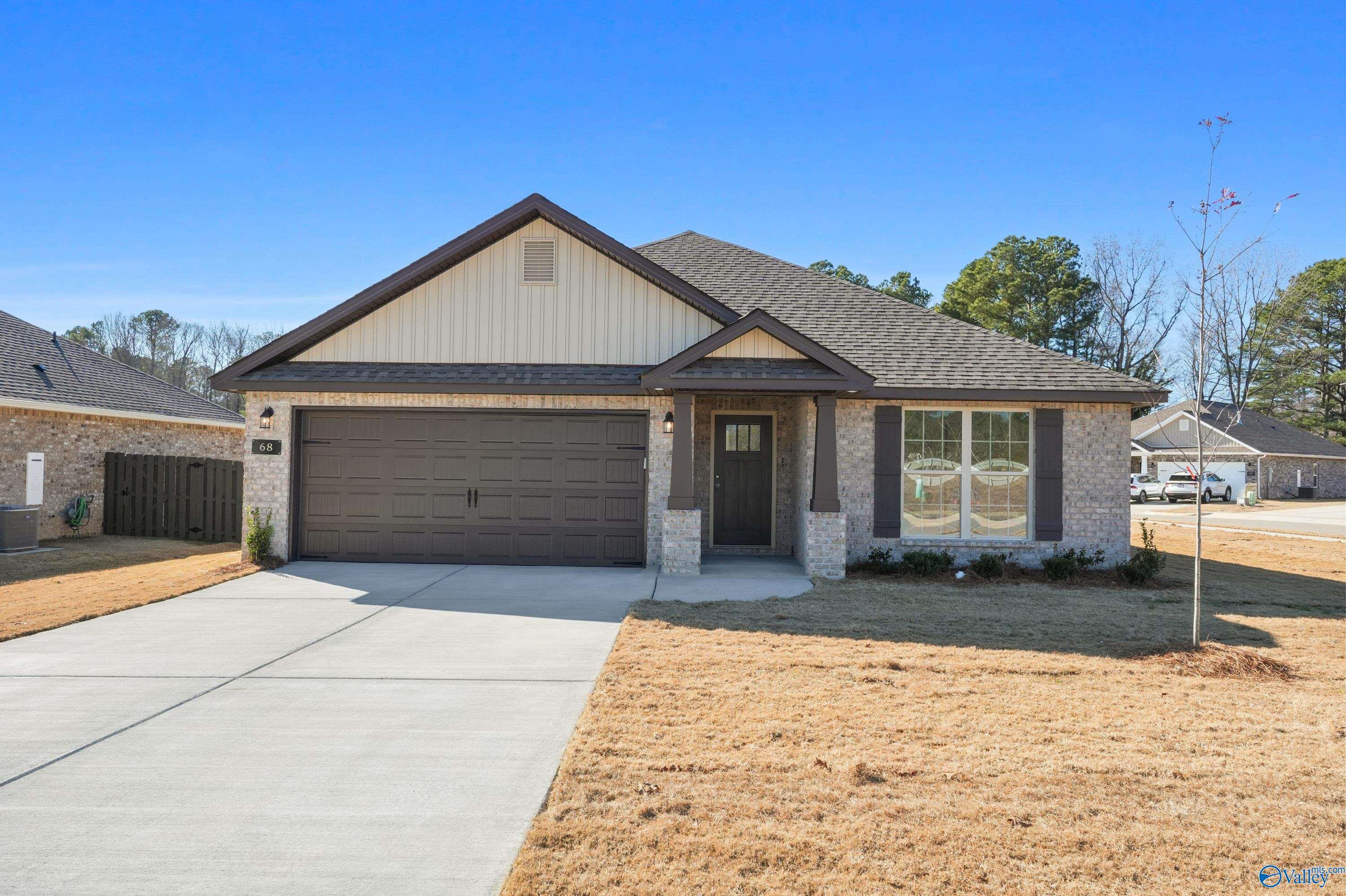 Modern 1-story 4-bedroom home with 2-car garage, beige siding, and covered entry in The Highlands, Arab, Alabama - Davidson Homes Daphne C