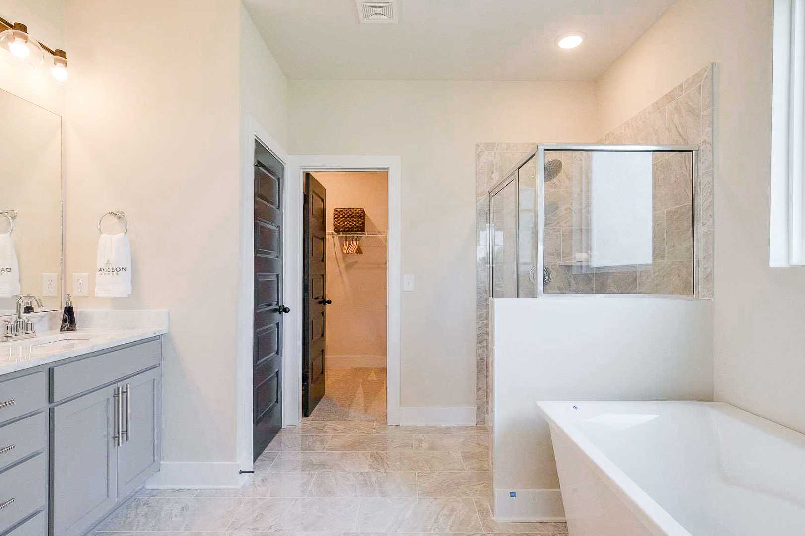 Luxurious master bathroom at The Meadows in Smyrna TN by Davidson Homes featuring double vanity, freestanding tub, and walk-in shower