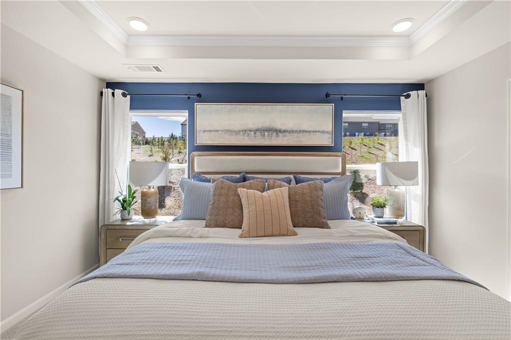 Elegant master bedroom with king bed, tray ceiling, blue accent wall, and scenic views in Davidson Homes The Burton C, Canton, GA
