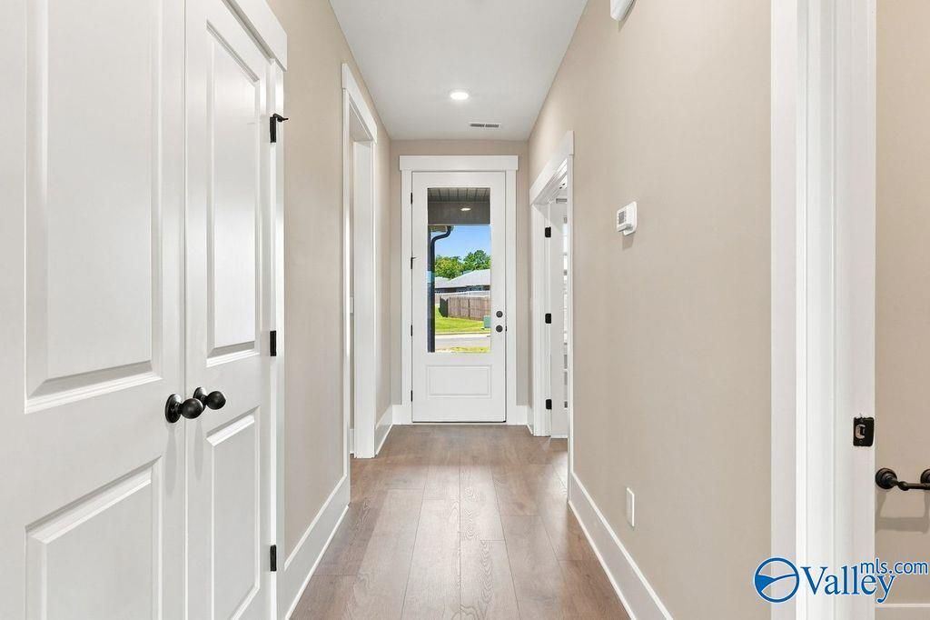Bright hallway with wood-style flooring and glass-paneled back door in The Rockford floor plan at Cain Park, Hartselle.