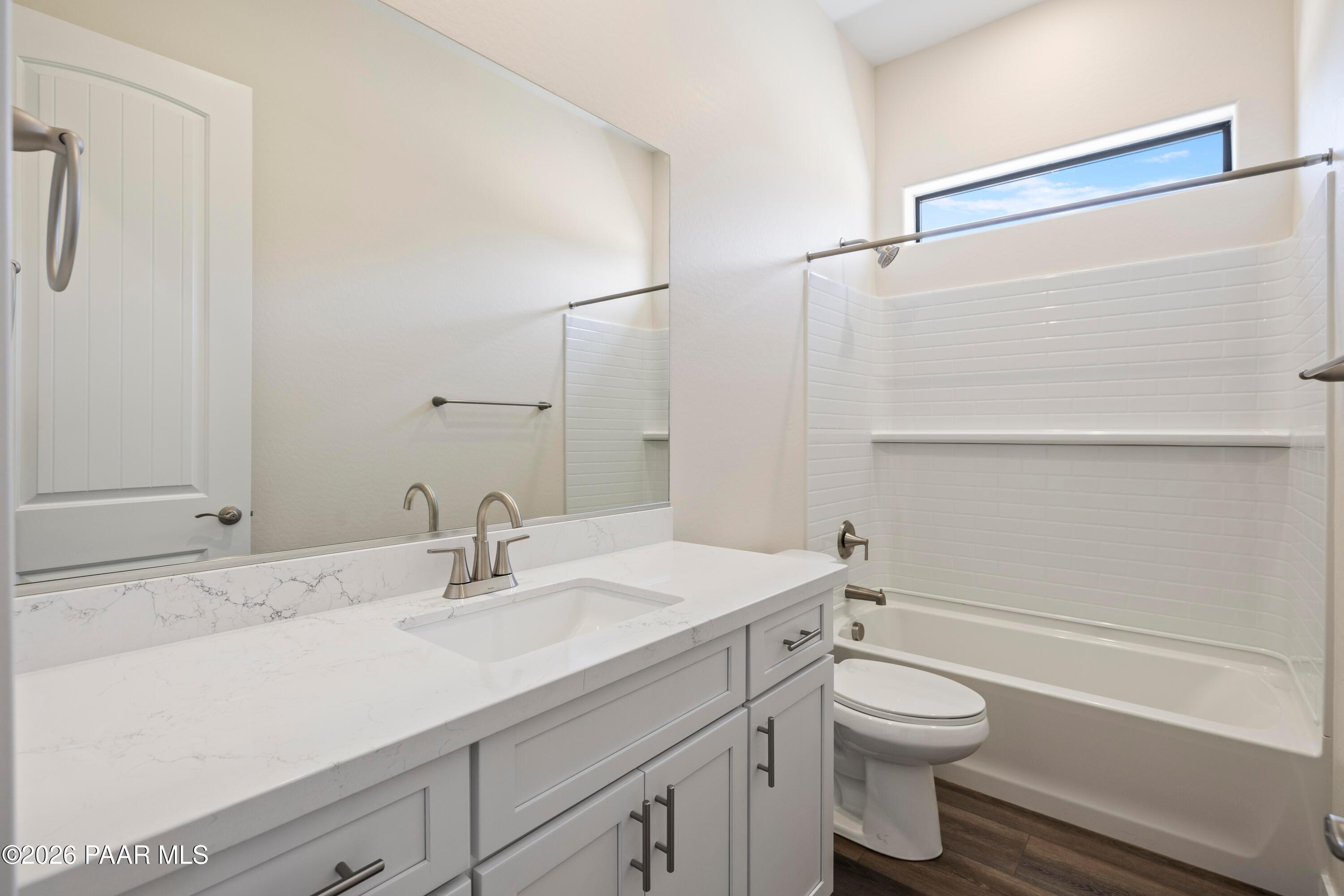 Elegant secondary bathroom with white shaker vanity, quartz countertop, tub-shower combo in Davidson Homes Soleil E, Prescott AZ