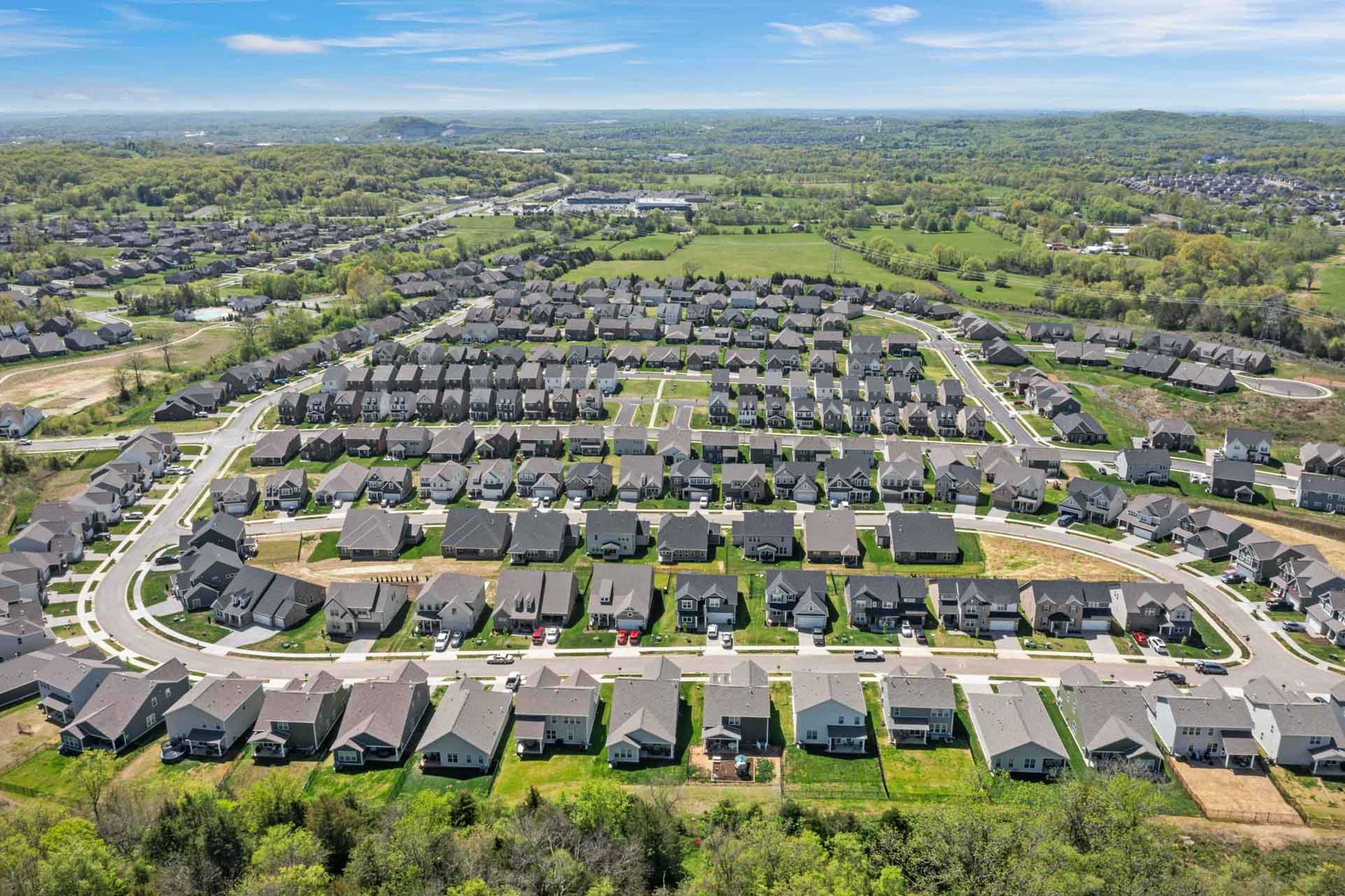 Aerial view of Carellton neighborhood in Gallatin TN featuring modern clustered homes, winding streets and lush green spaces by Davidson Homes