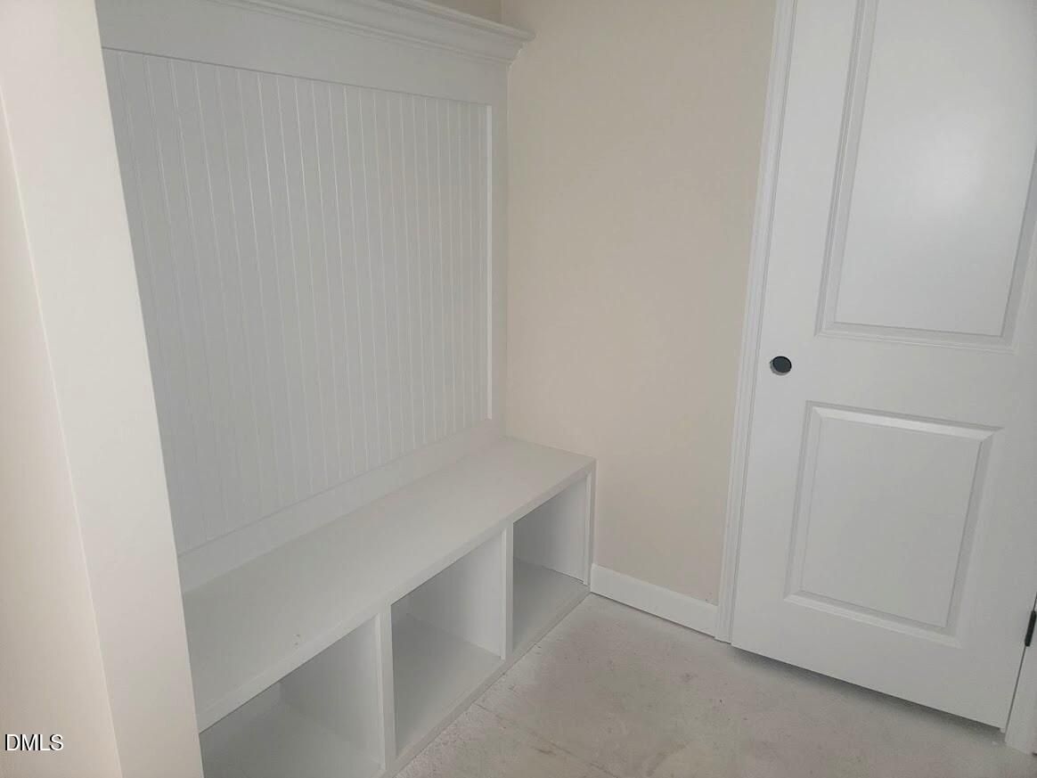 White built-in mudroom bench with cubbies, hooks, and storage in Davidson Homes The Cypress B II, Angier, North Carolina
