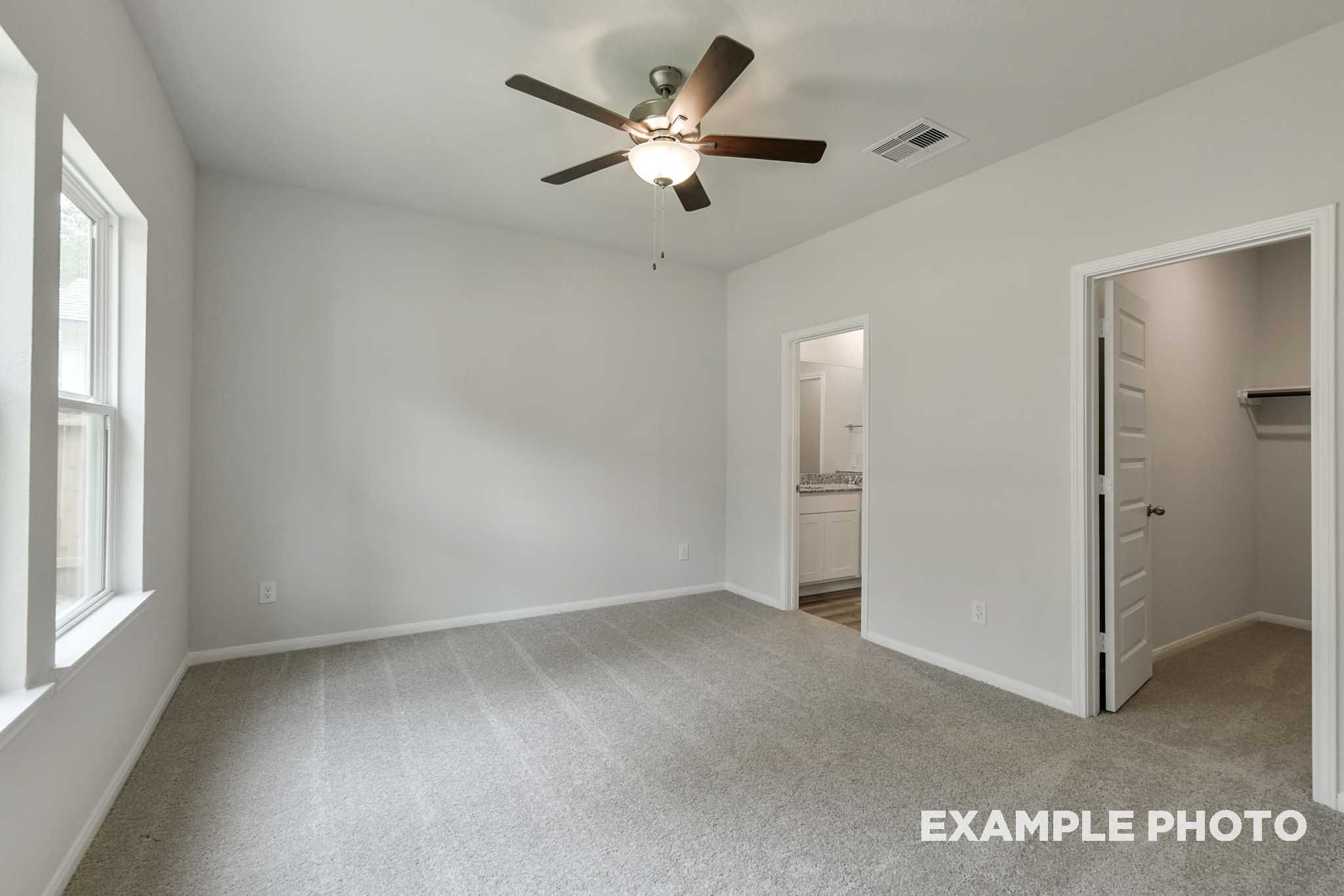Spacious secondary bedroom in The Frio floor plan featuring plush carpeting, ceiling fan, and access to a walk-in closet.