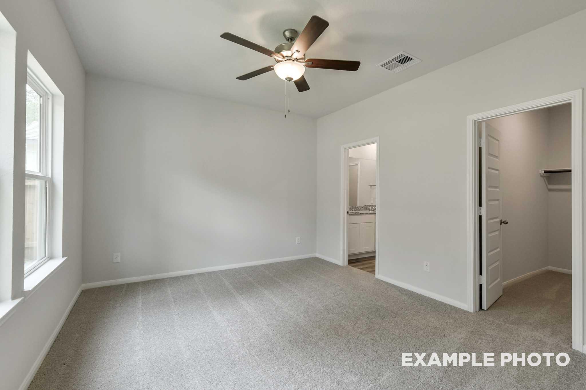 Spacious secondary bedroom in The Frio floor plan featuring plush carpeting, ceiling fan, and access to a walk-in closet.