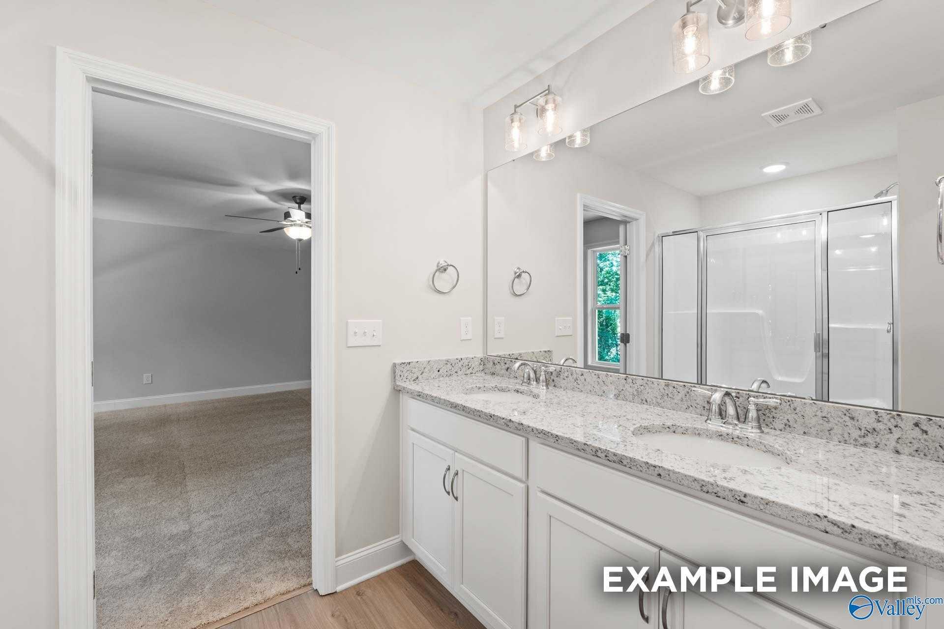 Modern master bathroom with double white vanity, granite counters, dual sinks, and glass shower in Davidson Homes The Camden C, Huntsville