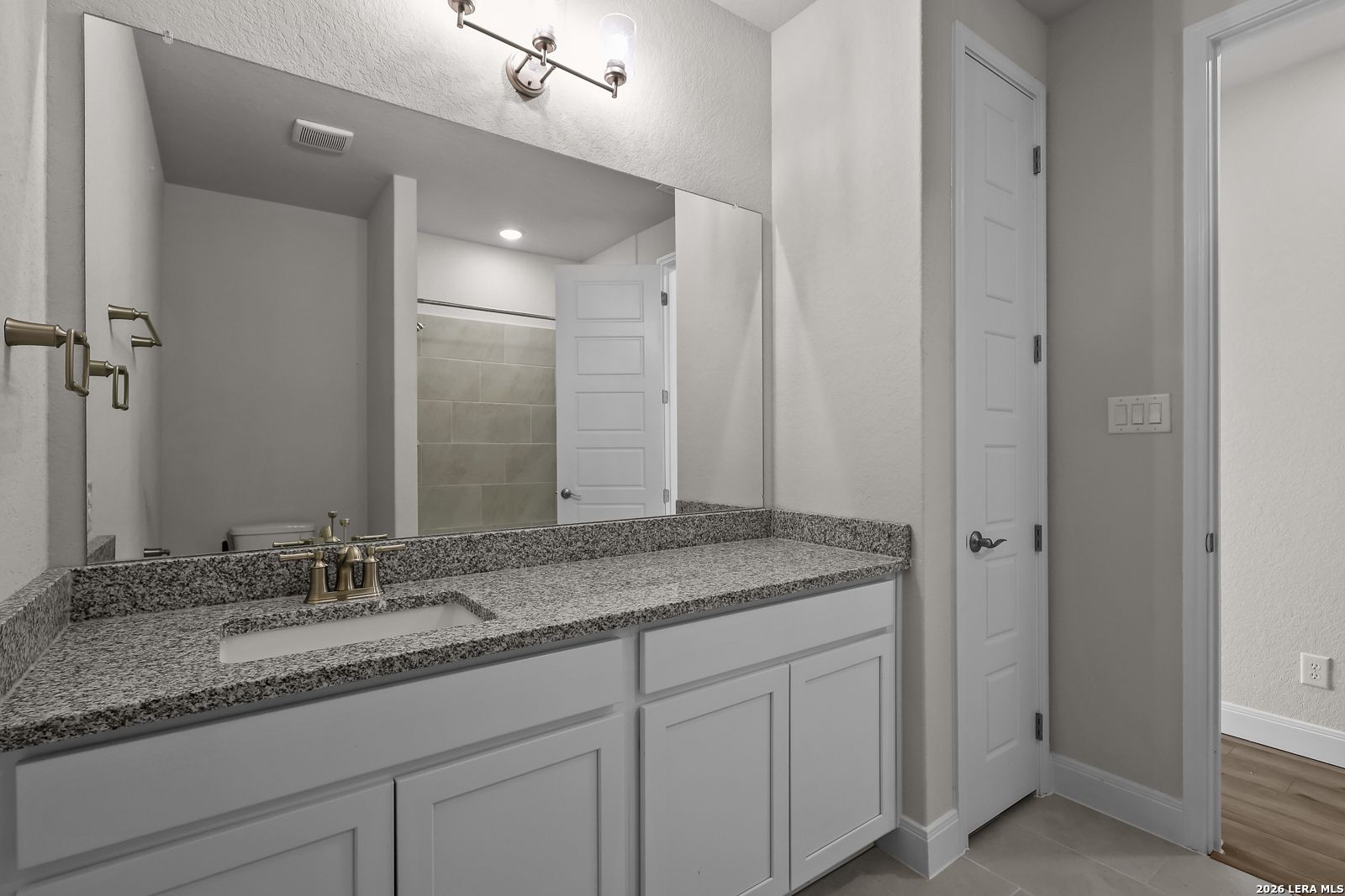 Modern bathroom vanity with granite countertop and white cabinets in The Lanier H floor plan by Davidson Homes in Ladera.
