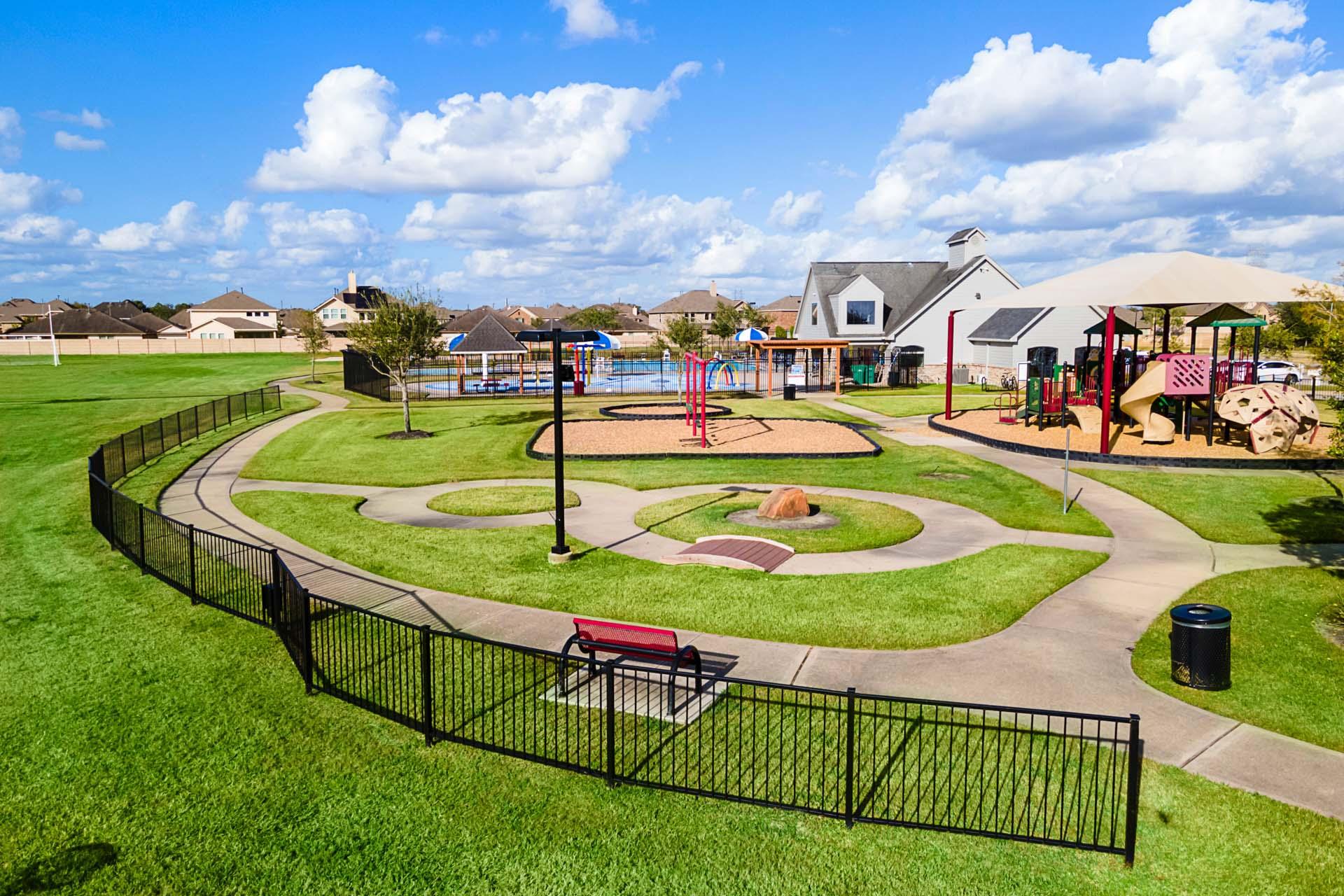 Vibrant playground at Sierra Vista in Rosharon Texas with colorful slides swings paths benches and green lawns