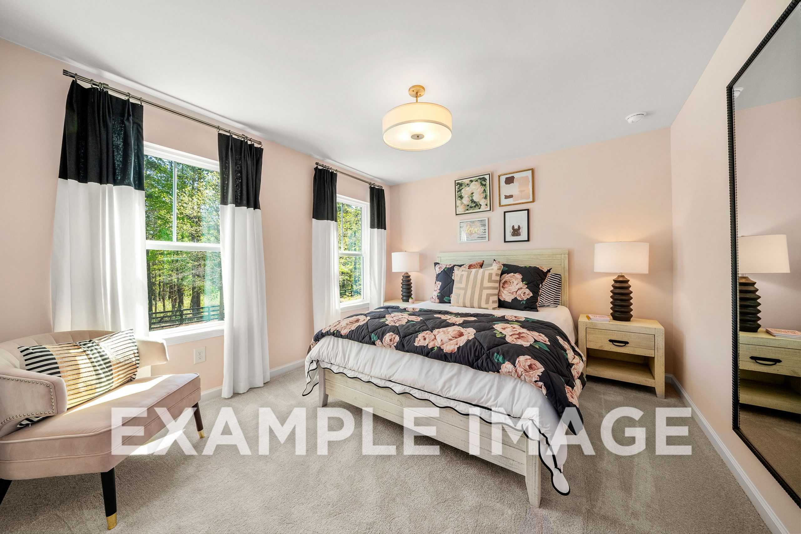 Spacious master suite in The Hickory A with king bed, floral bedding, chandelier, and window views