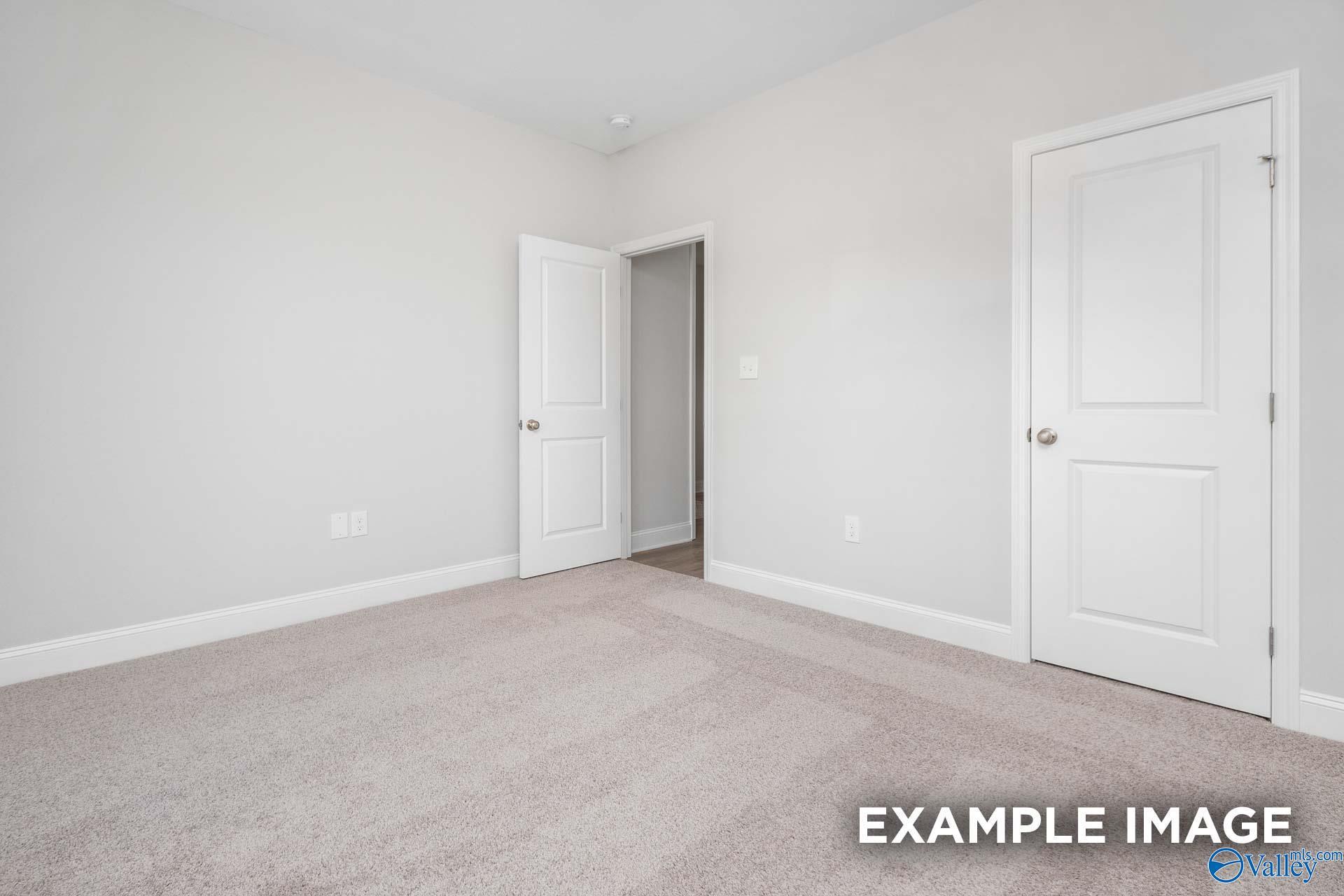 Empty secondary bedroom with neutral walls, white doors, and carpet in The Daphne D 4-bedroom home, Meridianville, Alabama