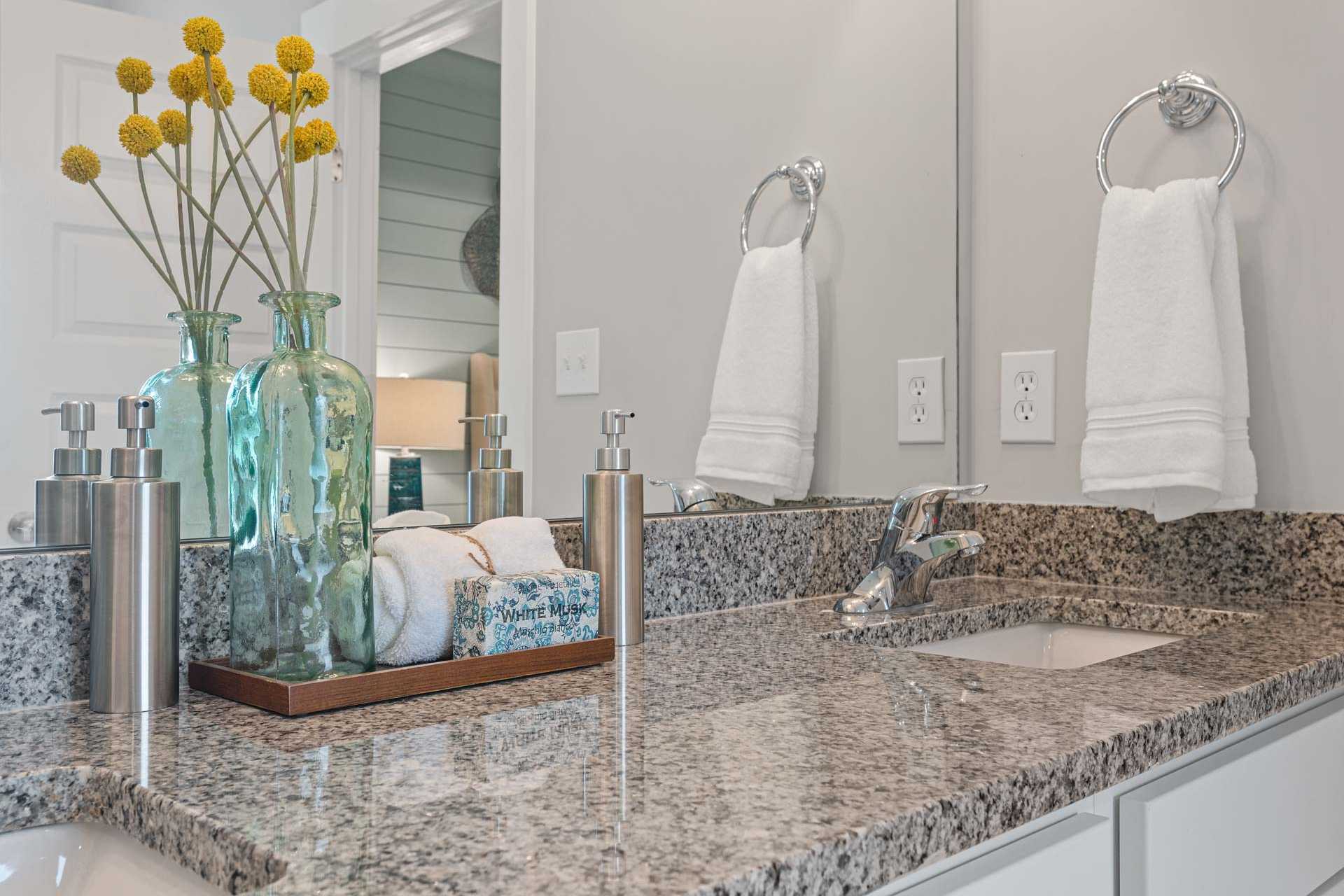 Elegant bathroom vanity at Monteagle Cove in Owens Cross Roads, Alabama with granite countertop, yellow flowers, and white towels