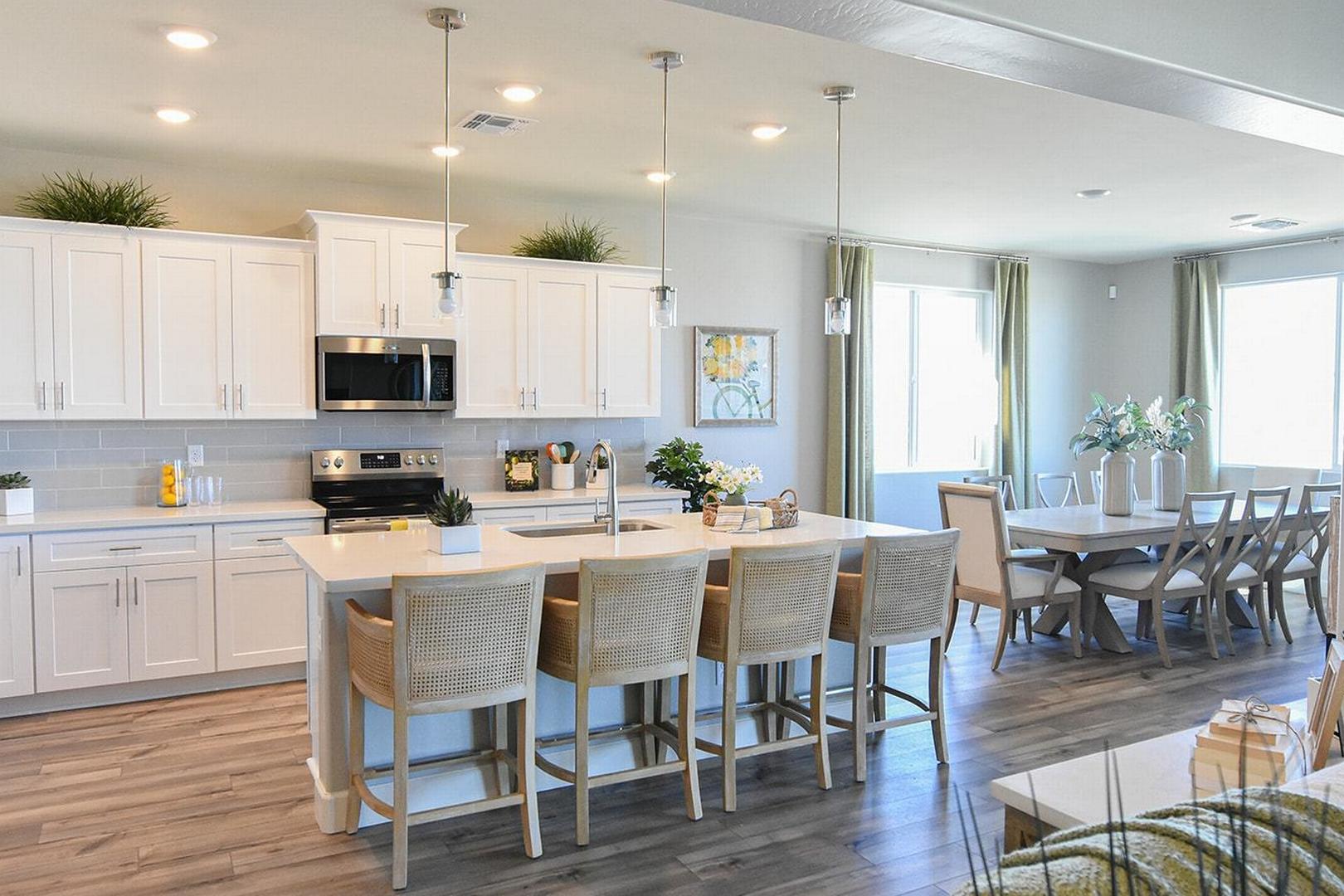 Spacious open-concept kitchen and dining in The Summit E featuring white shaker cabinets, quartz island, stainless appliances, Prescott Valley home