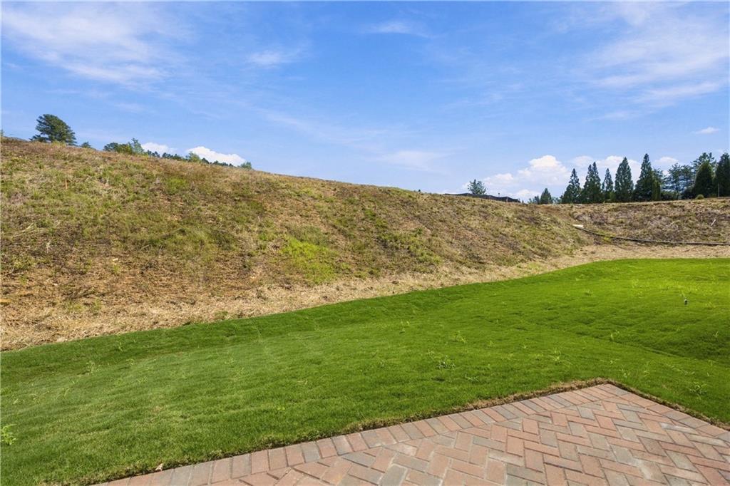 Herringbone brick patio overlooking spacious fenced backyard with lush green lawn at The Bluffs, Canton, Georgia Davidson Homes