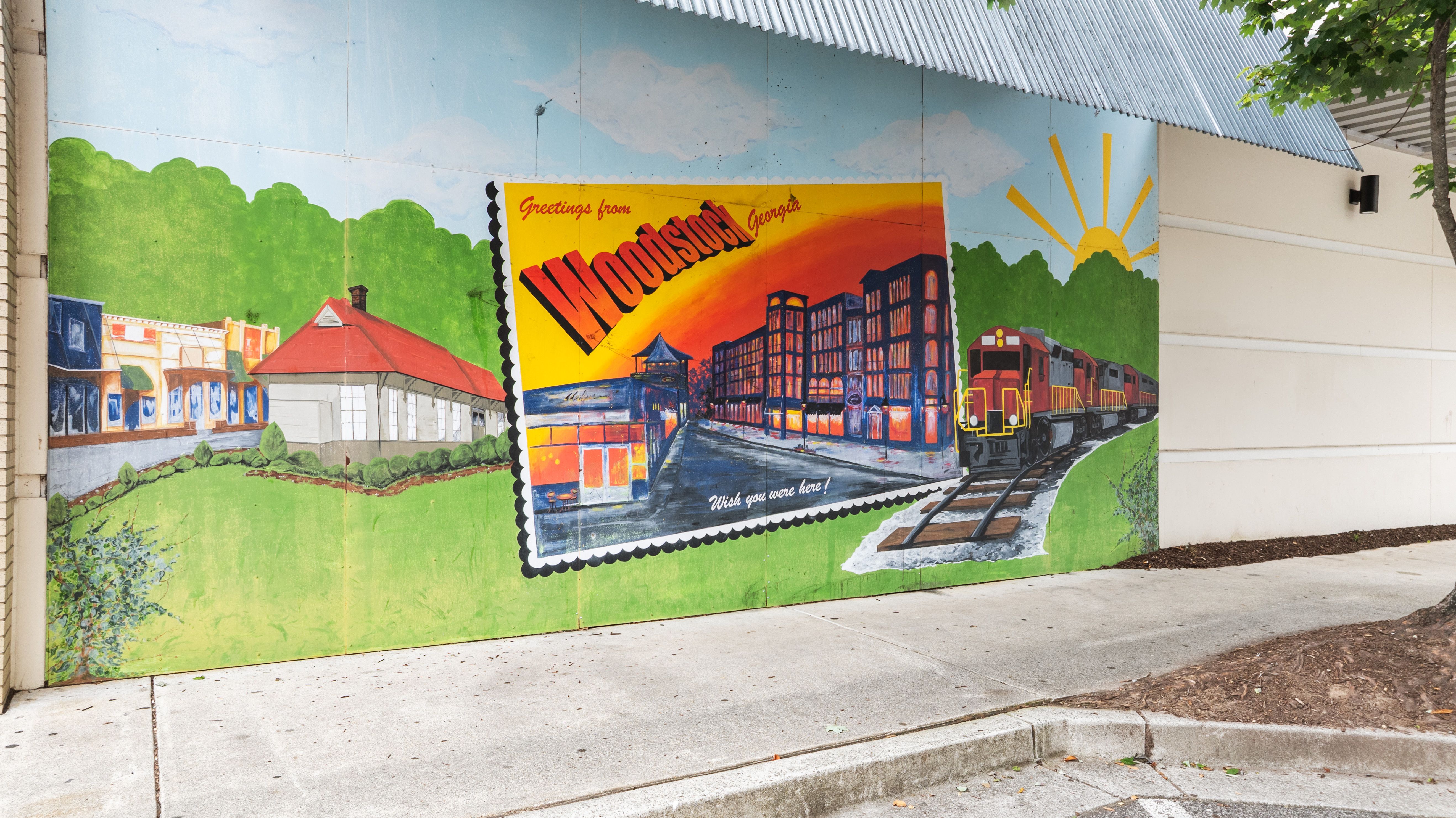 Greetings from Woodstock, Georgia mural depicting local landmarks and a train near the Grafton Trace community.