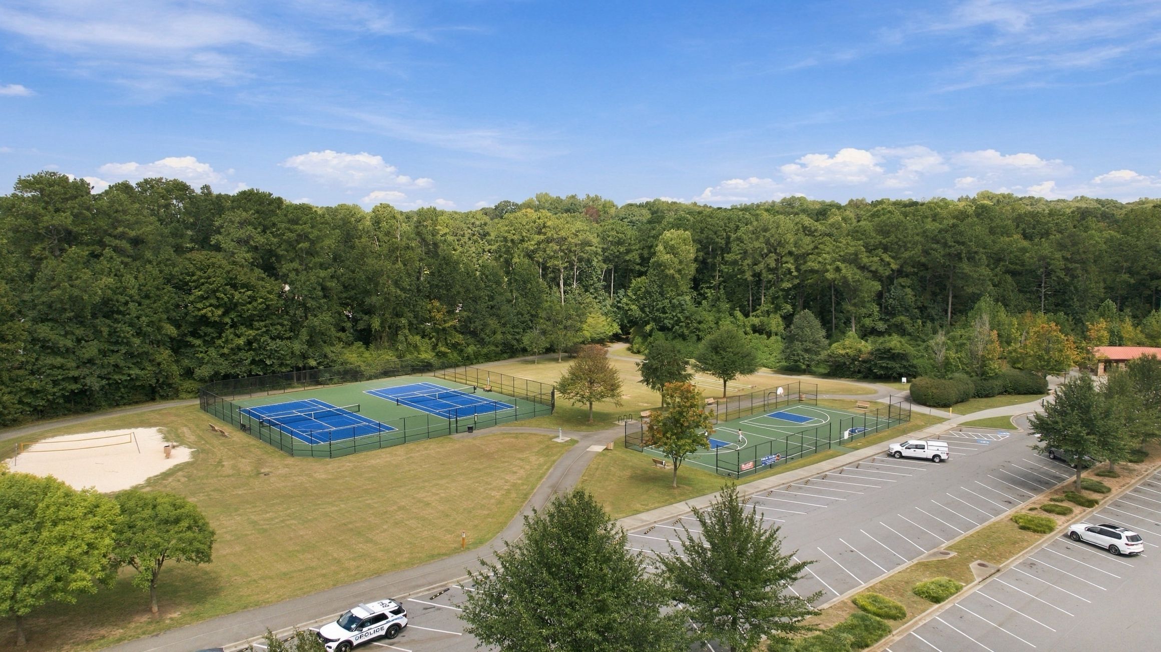 Aerial view of tennis and pickleball courts, basketball court, and sand volleyball pit near Alford at Bethesda in Lawrenceville, Georgia